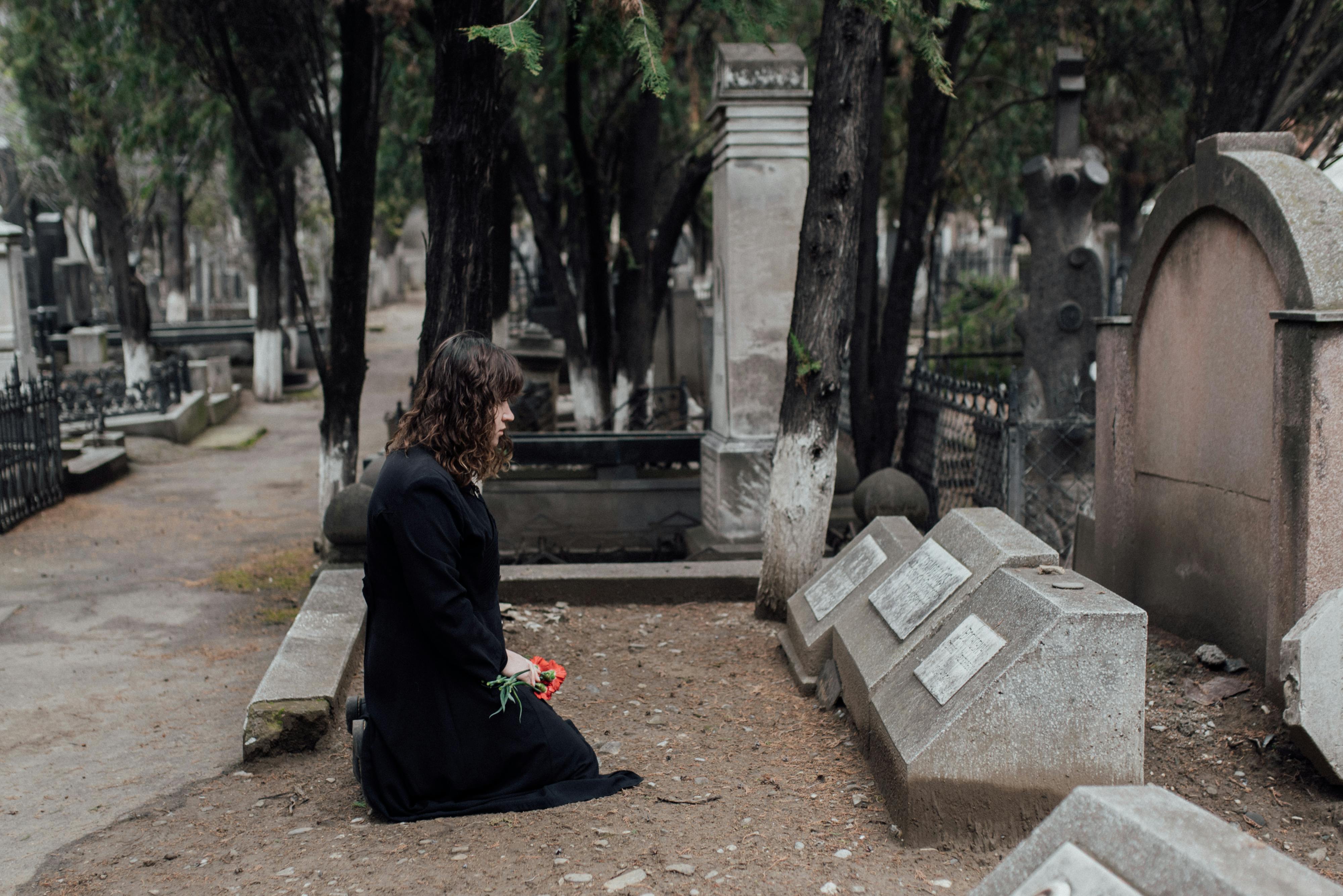 Mujer con vestido negro en una tumba | Fuente: Pexels