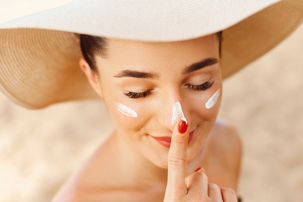 Modelo con sombrero y protector solar en la cara. | Foto: Shutterstock