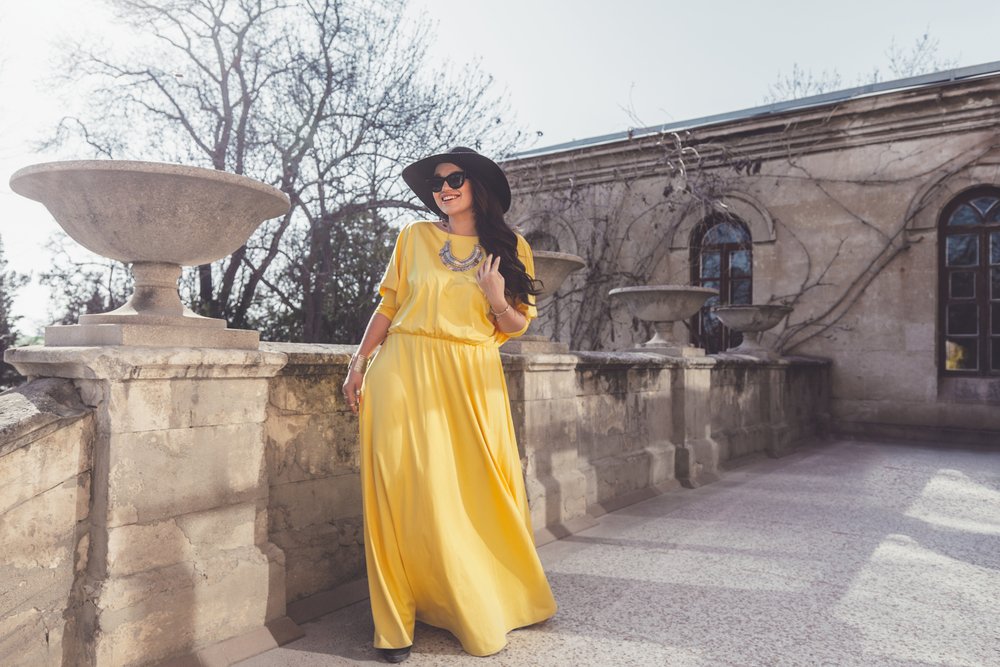 Modelo femenina luciendo un maxi vestido amarillo. I Foto: Shutterstock.