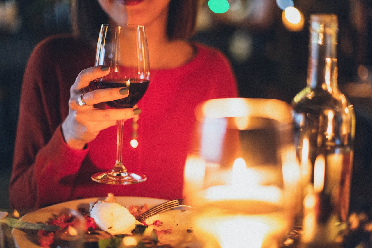 Una mujer con una copa de vino en la mano | Fuente: Pexels