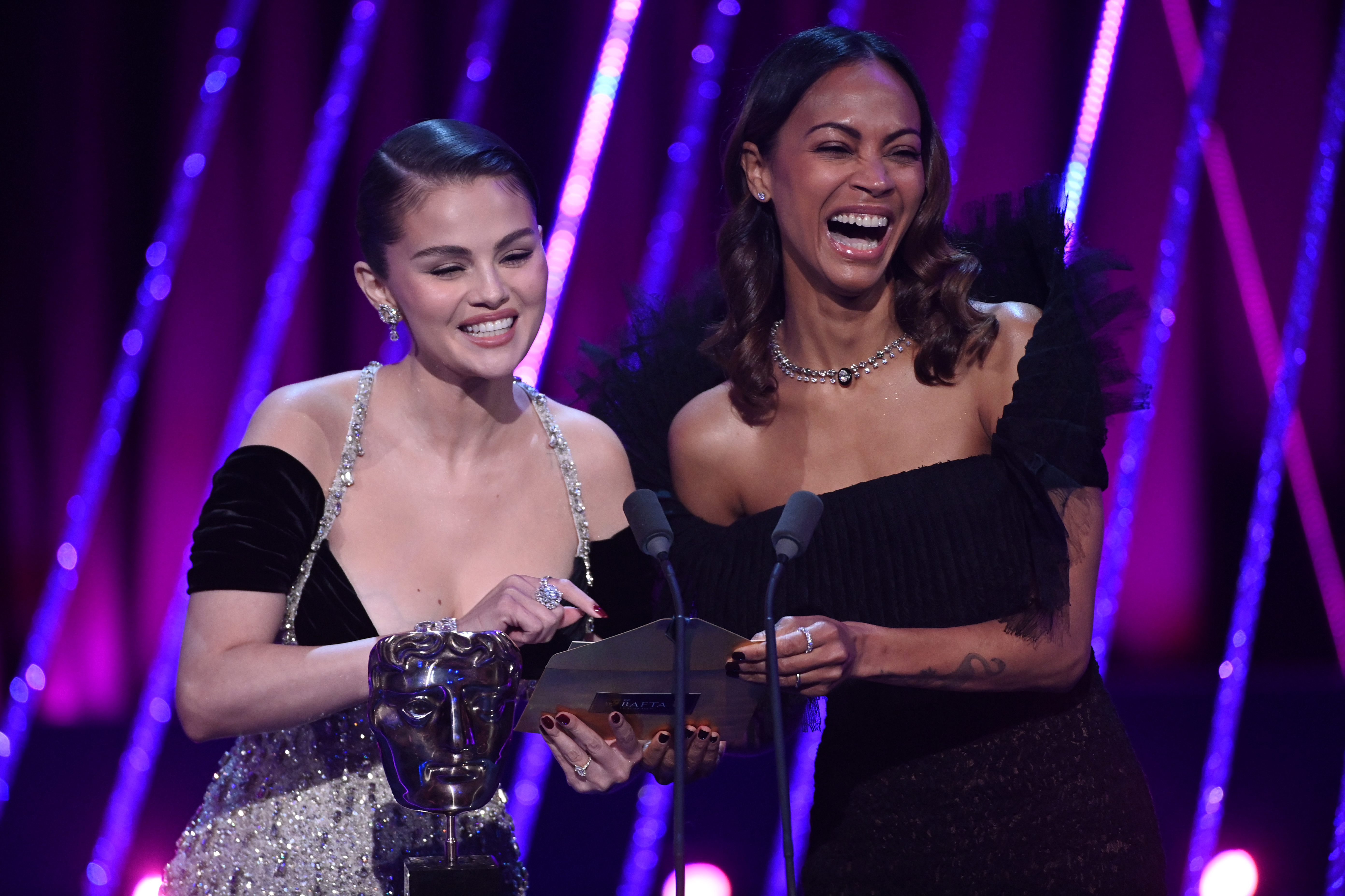 Selena Gomez y Zoe Saldaña presentan el Debut Sobresaliente de un Escritor, Director o Productor Británico en el escenario durante los EE BAFTA Film Awards 2025 en Londres, Inglaterra, el 16 de febrero de 2025 | Fuente: Getty Images