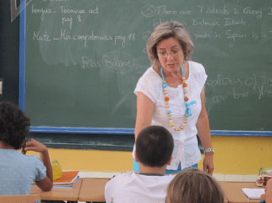 Maestra dando indicaciones a un alumno en el aula de clase. | Foto: Flickr