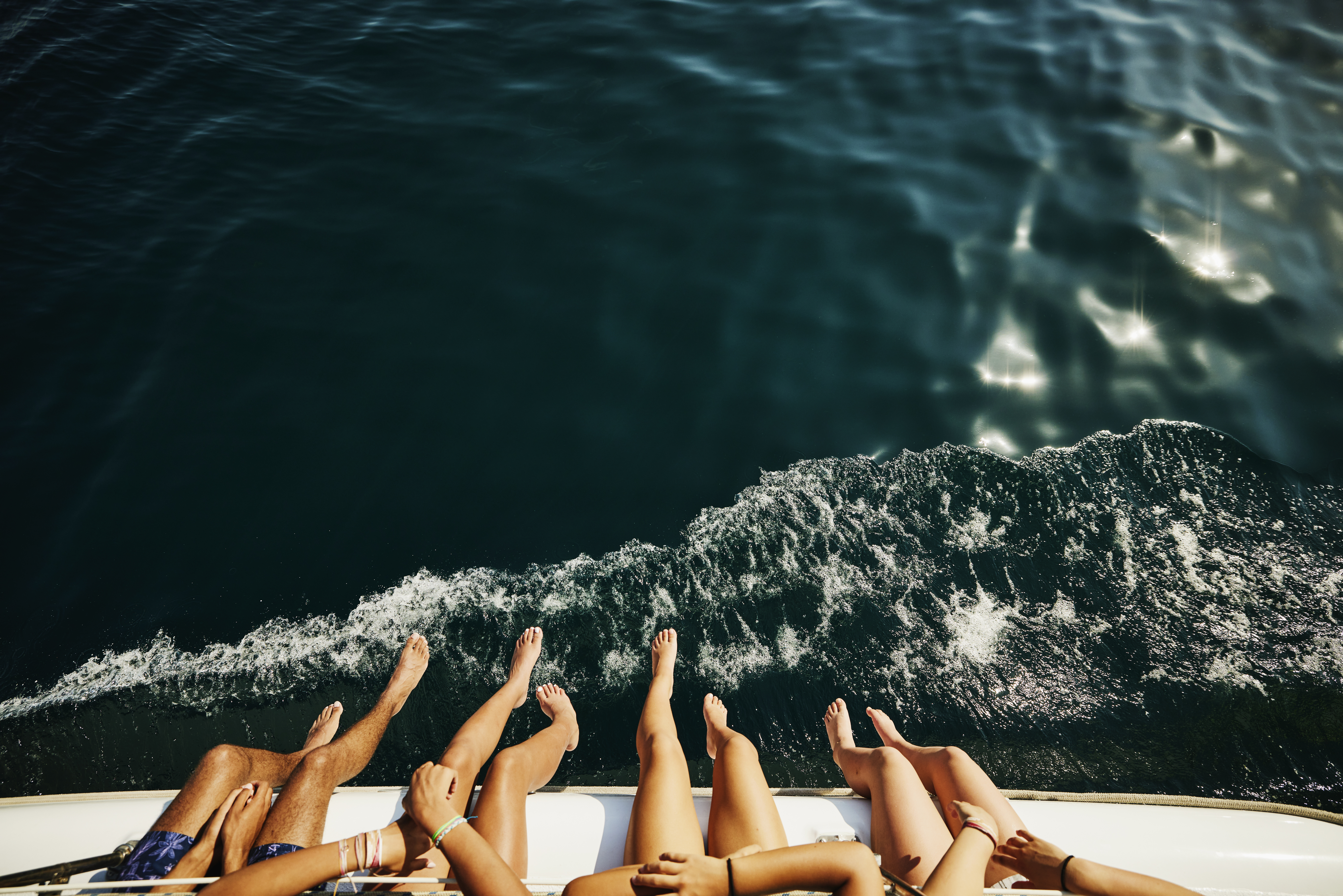 Una toma de gente colgando las piernas por el borde de un barco | Foto: Getty Images
