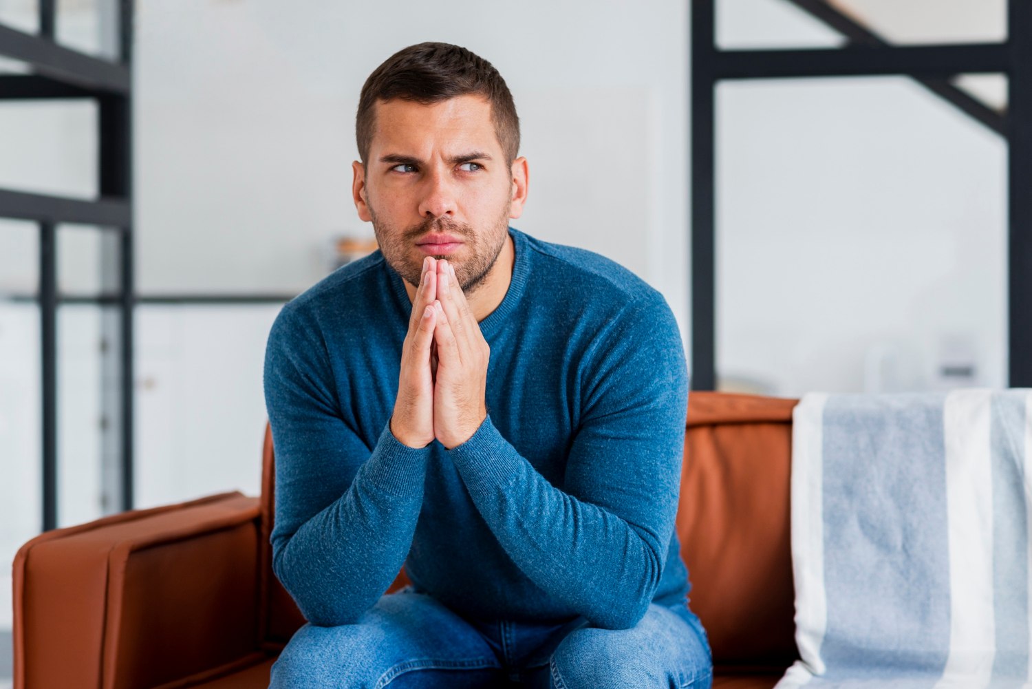 Un hombre ansioso sentado en el sofá | Fuente: Freepik