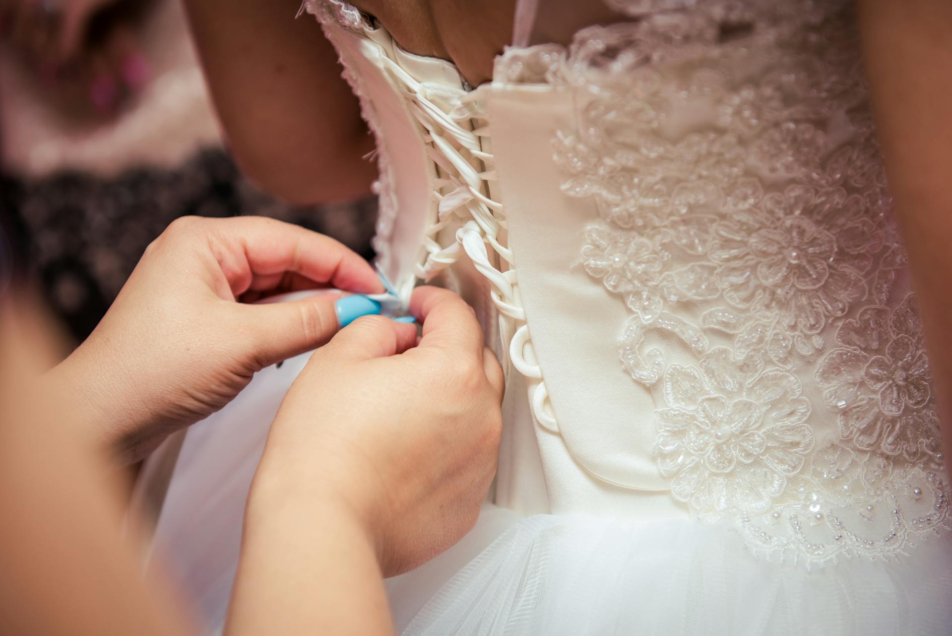 Primer plano de una mujer arreglando un vestido de novia | Fuente: Pexels