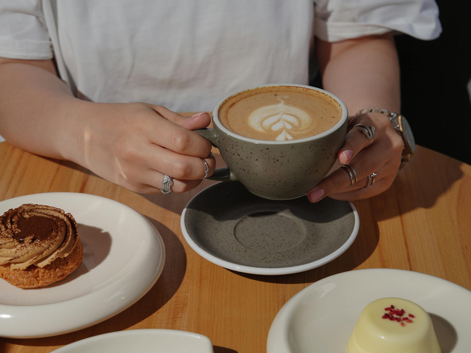 Primer plano de una mujer sentada a la mesa con una taza de café | Fuente: Pexels