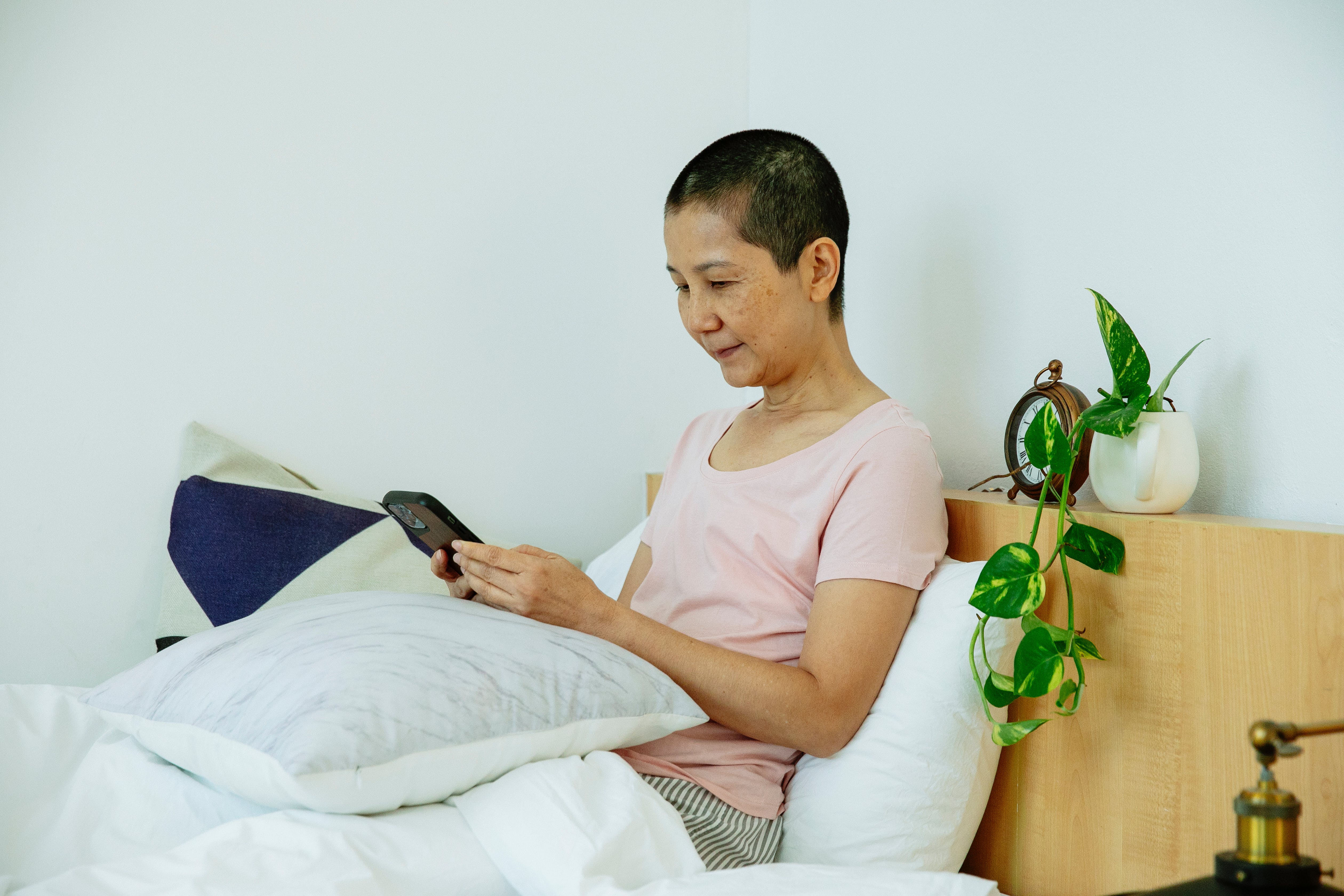 Mujer en su cama usando un smartphone┃Foto: Pexels