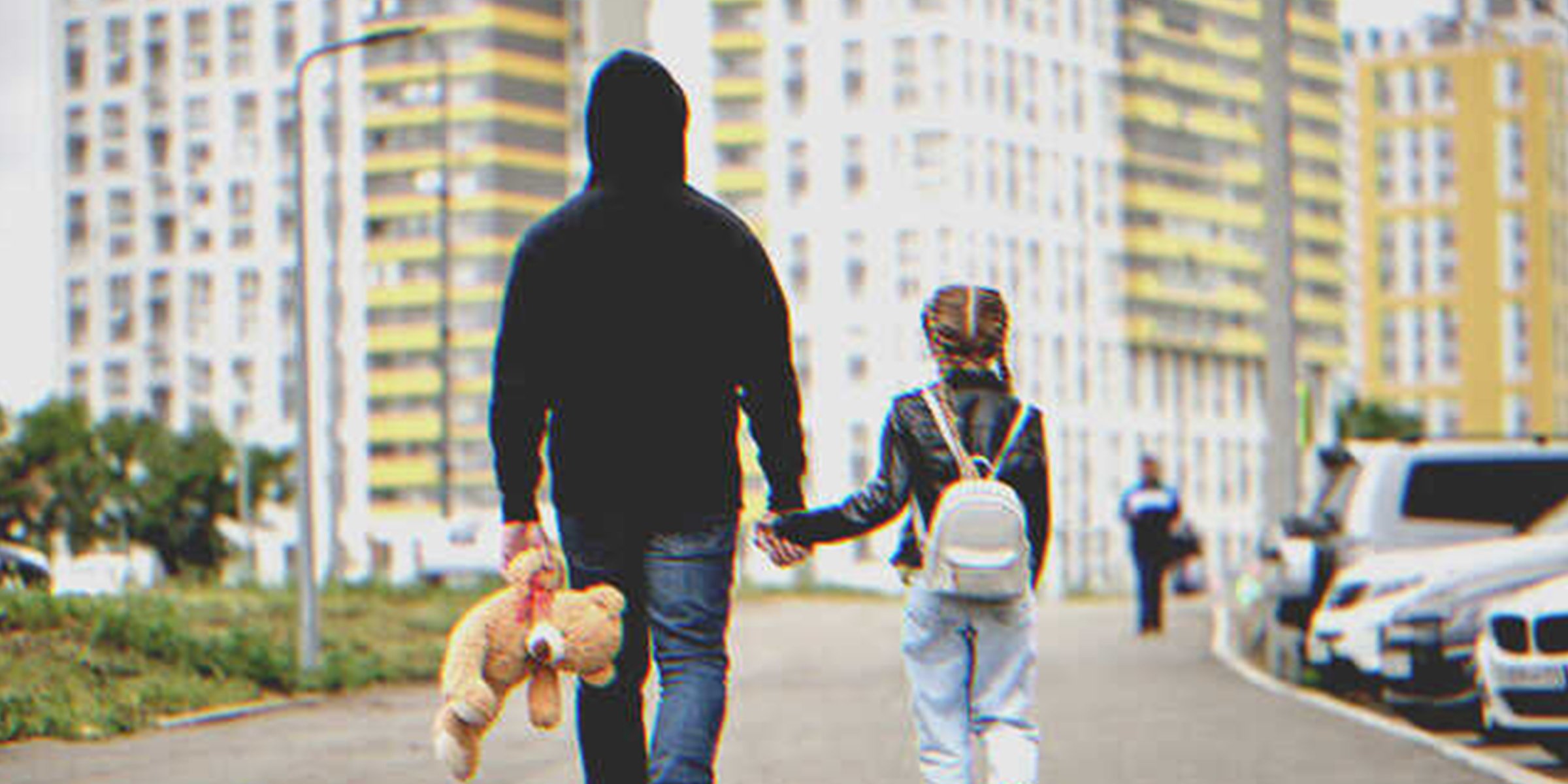 Niña caminando con un hombre que lleva un oso de peluche | Foto: Shutterstock