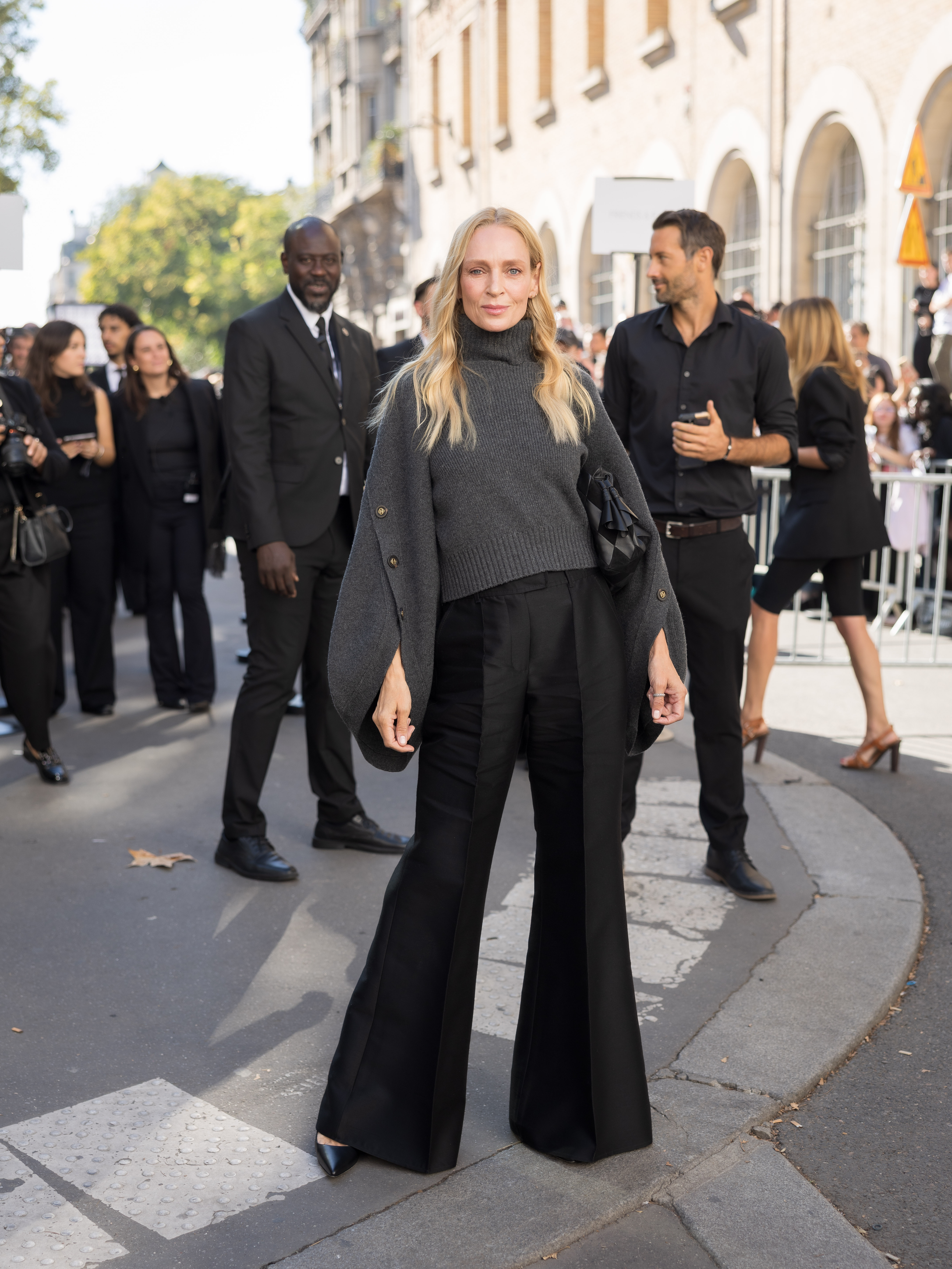 Los pantalones anchos y acampanados son el detalle más llamativo del look totalmente negro de Uma Thurman. Los combinó con un jersey holgado de color carbón durante su aparición en París para Zimmermann. | Fuente: Getty Images