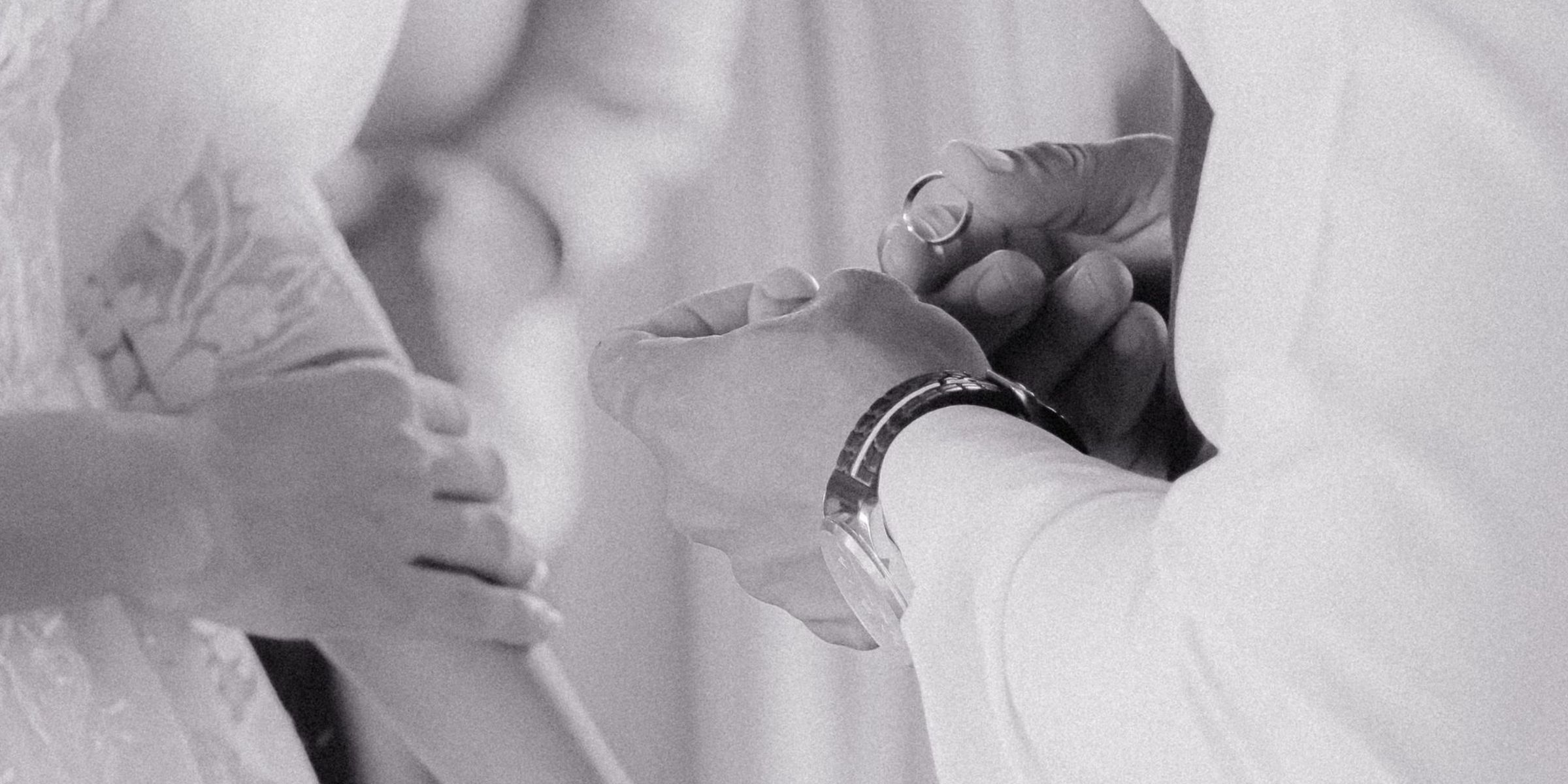 Una foto en blanco y negro en primer plano de unos novios intercambiando anillos | Fuente: Pexels