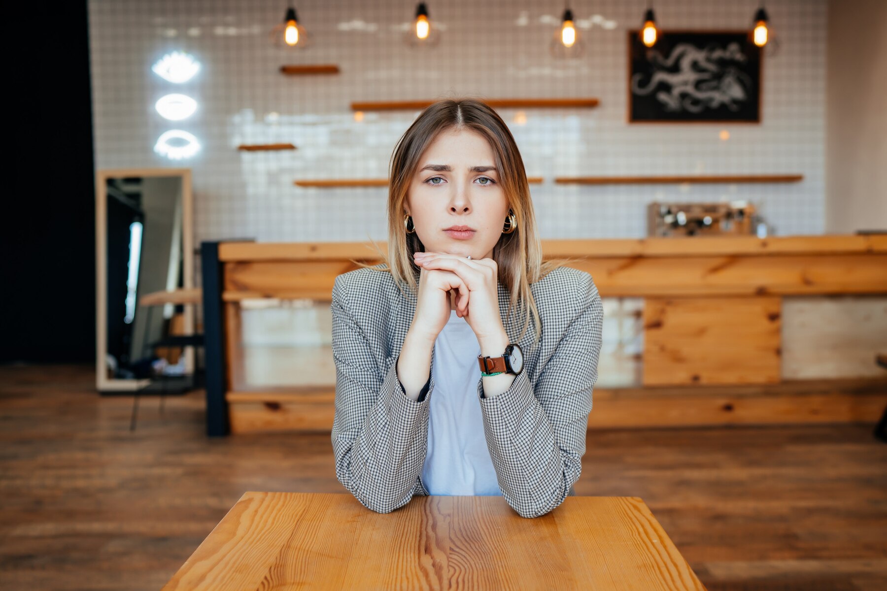 Una mujer seria en un café | Fuente: Freepik