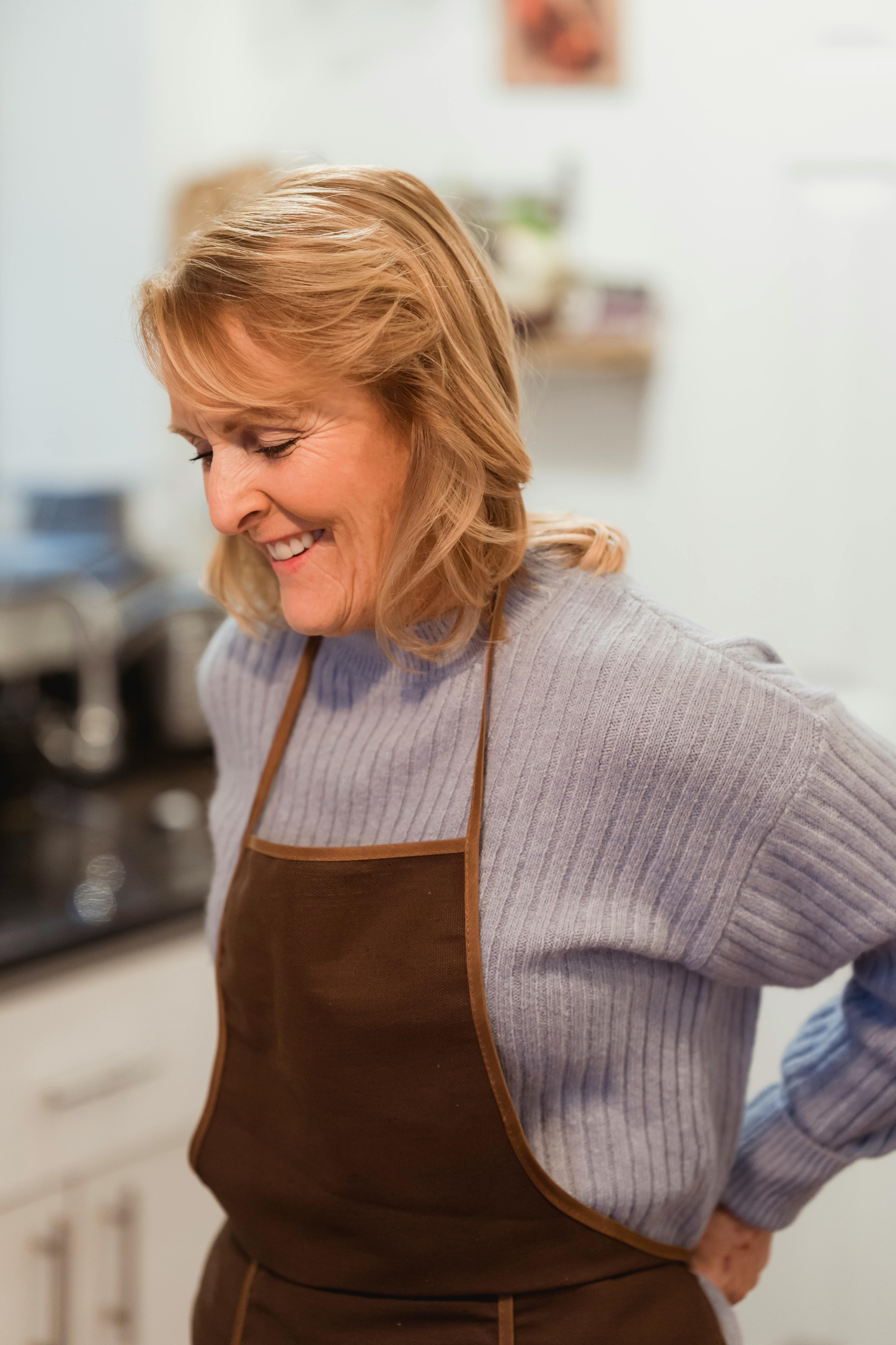 Una mujer feliz con delantal | Fuente: Pexels