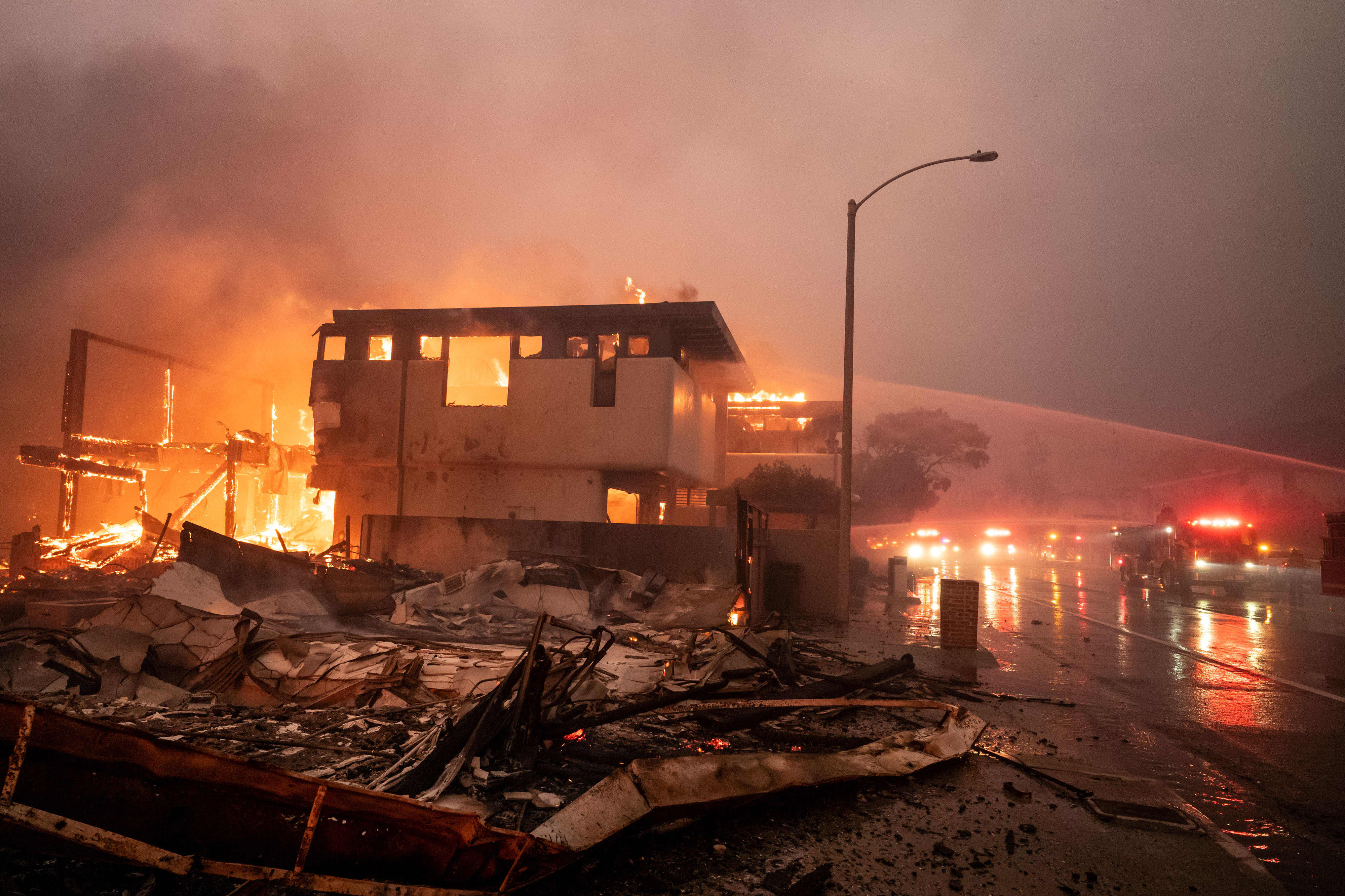 Los bomberos siguen luchando contra el viento y el fuego mientras las casas arden en llamas en Malibú, junto a la autopista de la Costa del Pacífico, en el incendio de Palisades, el 8 de enero de 2025 | Fuente: Getty Images