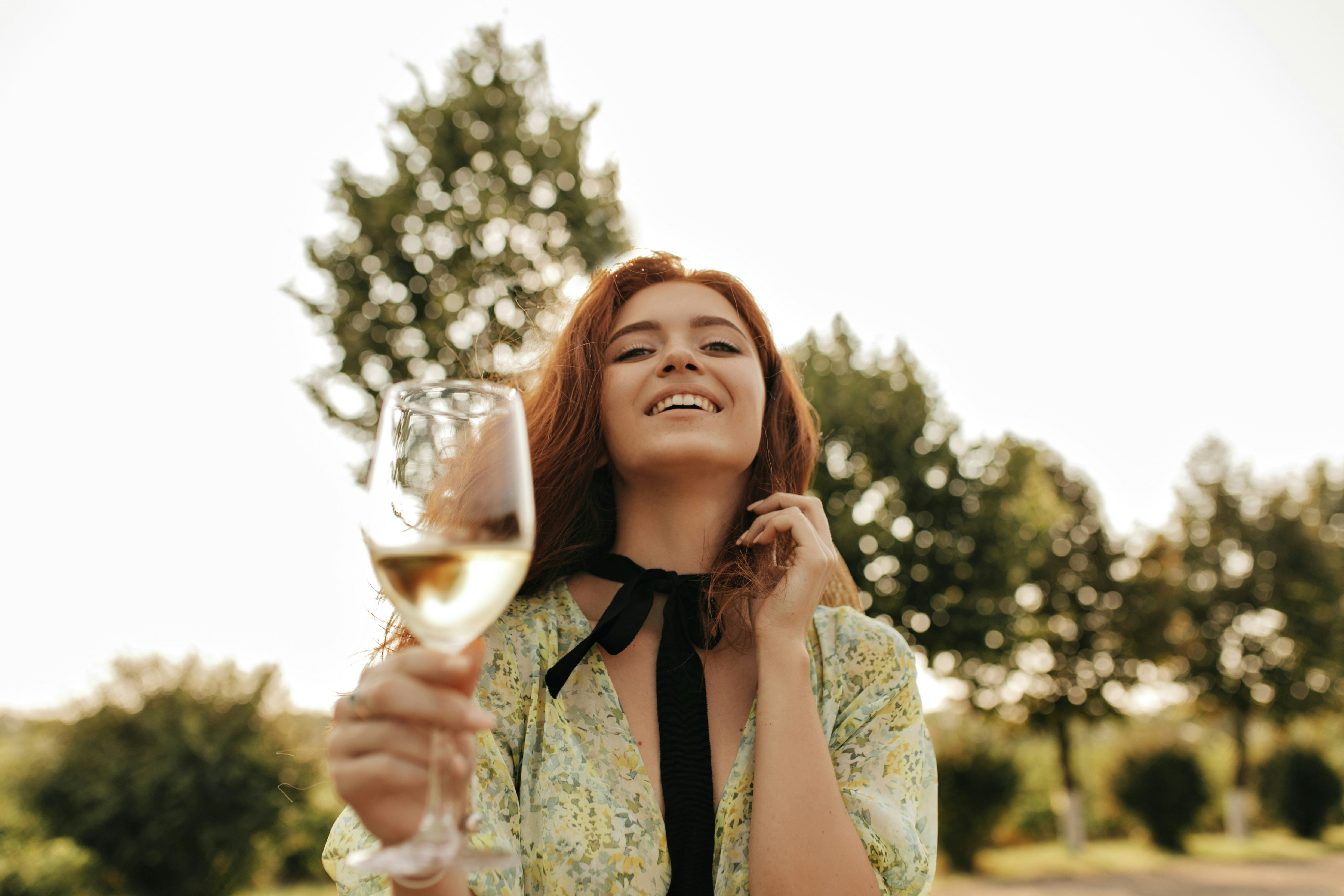 Una mujer riendo mientras sostiene una copa de vino | Fuente: Unsplash