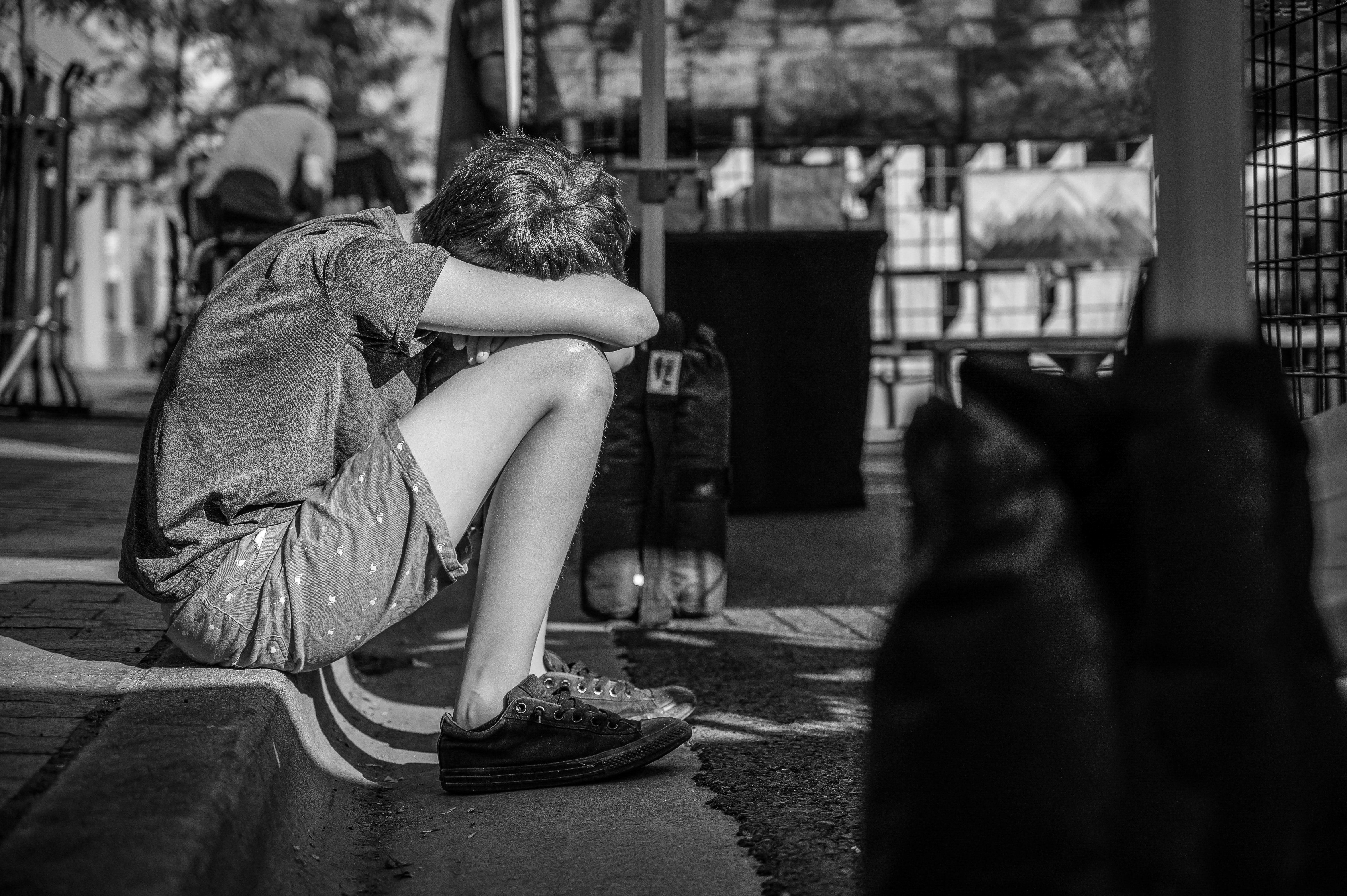 Niño llora con el rostro entre sus piernas. | Foto: Pexels