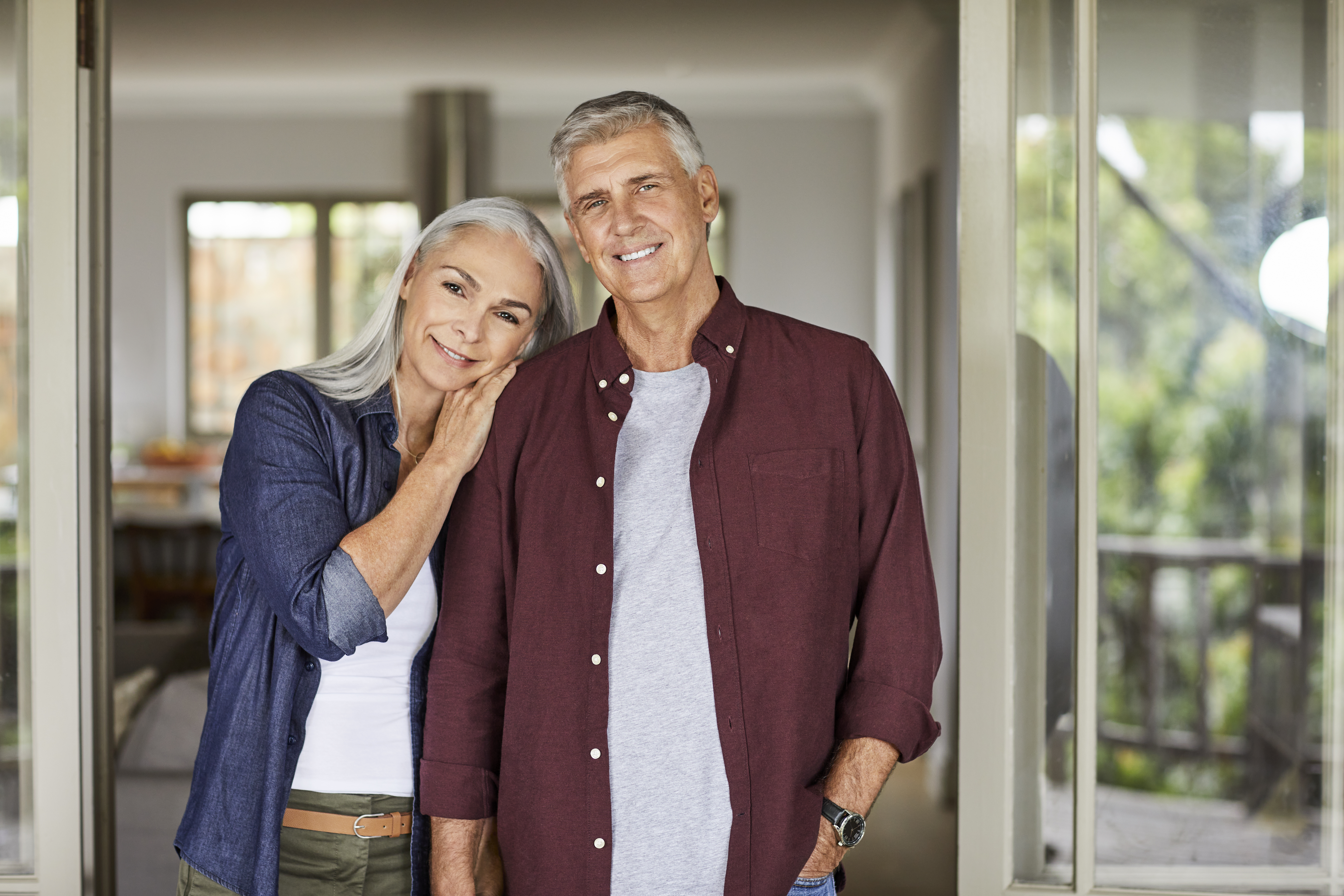 Pareja madura sonriente en su casa durante el encierro | Fuente: Getty Images