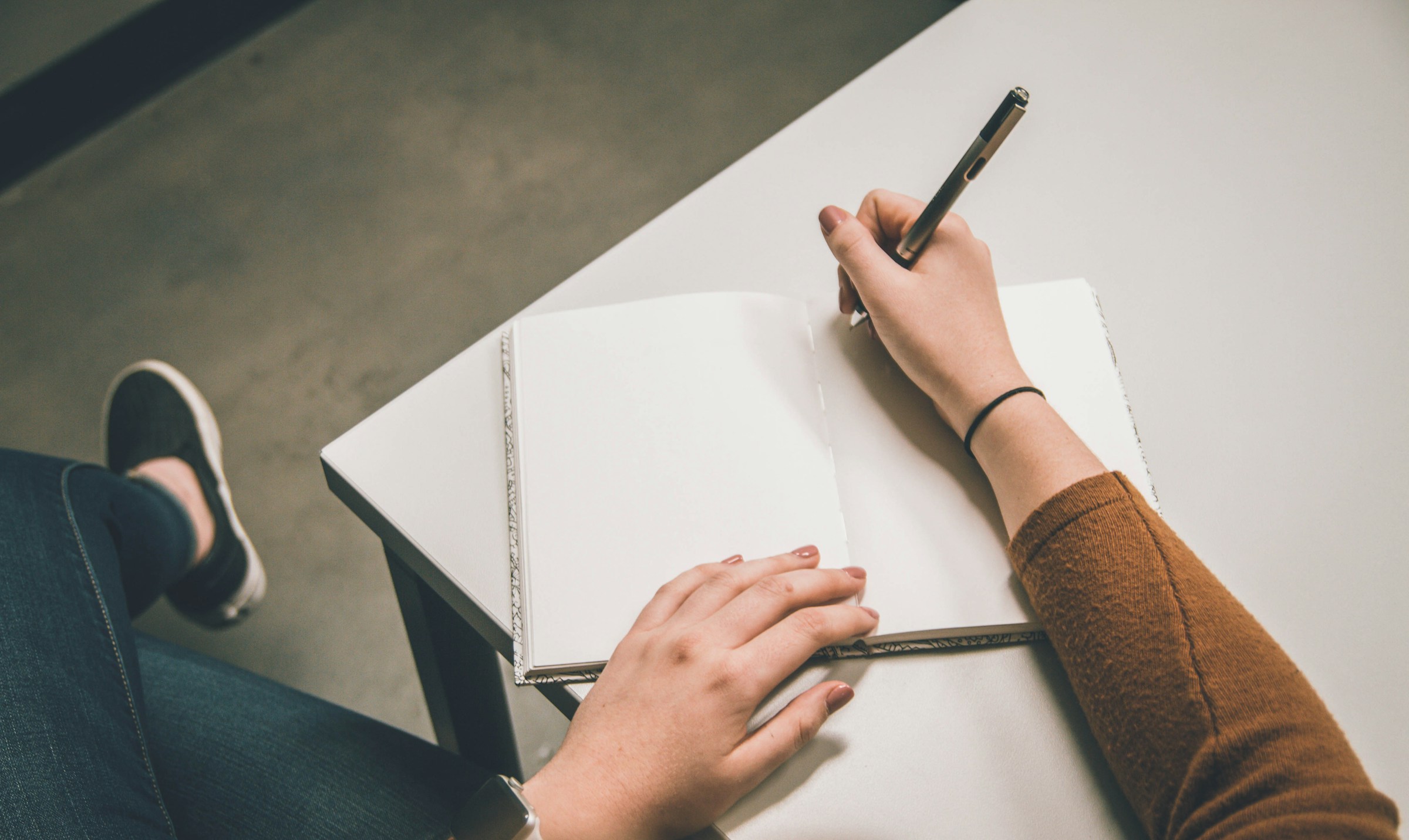 Una persona che scrive su un foglio di carta | Fonte: Unsplash