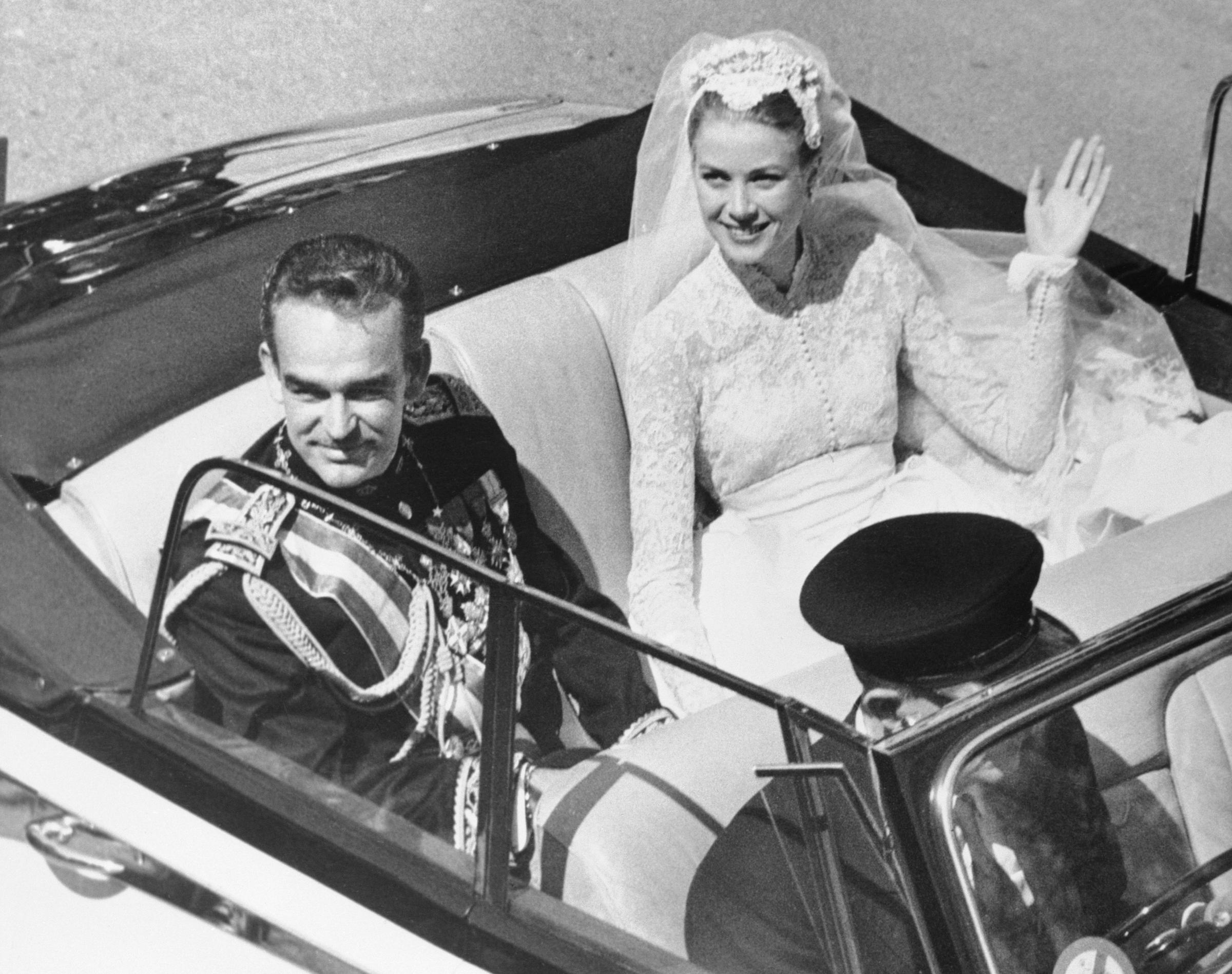 El Príncipe Rainiero III y Grace Kelly fotografiados en un Automóvil descapotable tras su boda religiosa el 19 de abril de 1956, en Mónaco. | Fuente: Getty Images