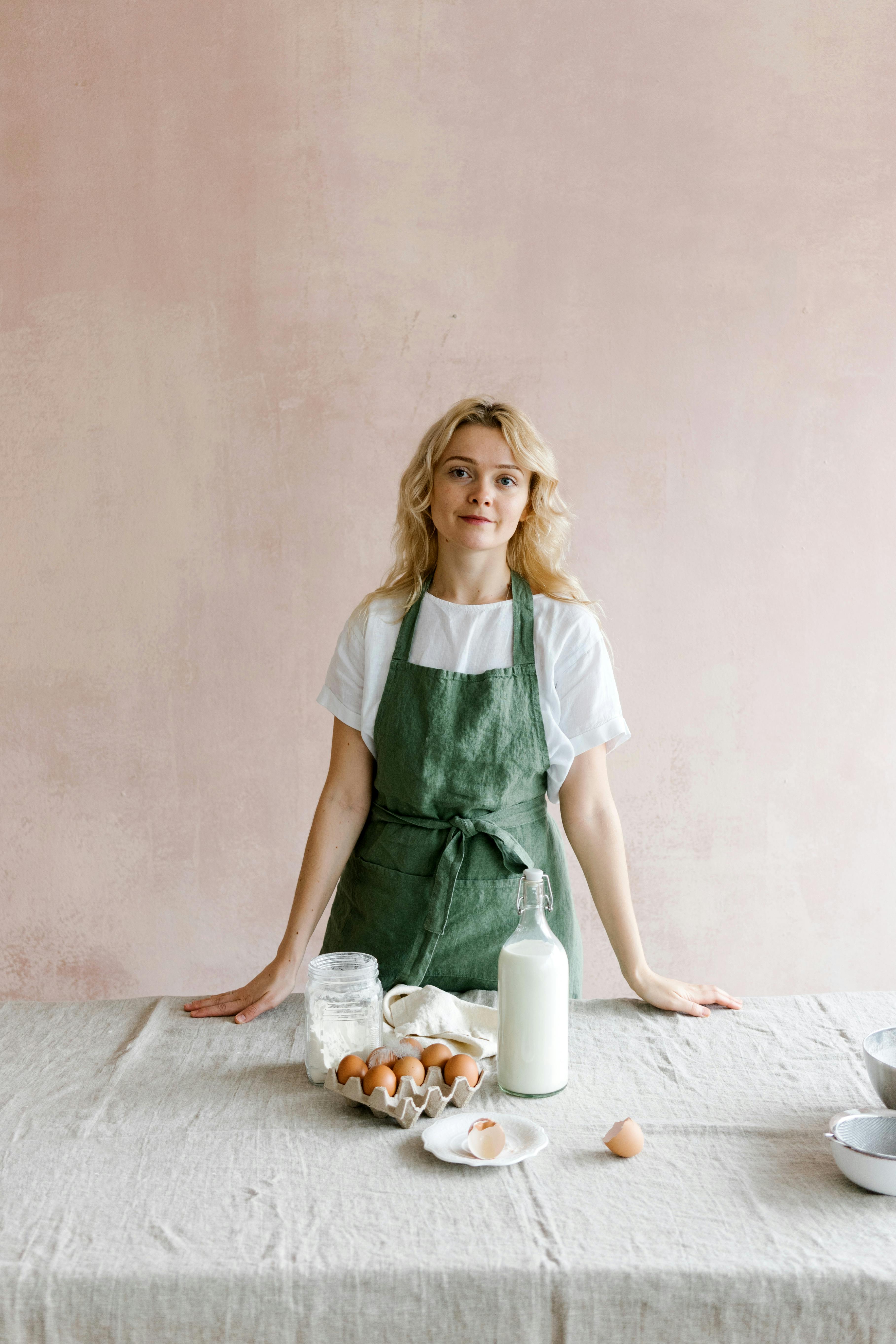 Mujer con delantal en la mesa cocinando | Foto: Pexels