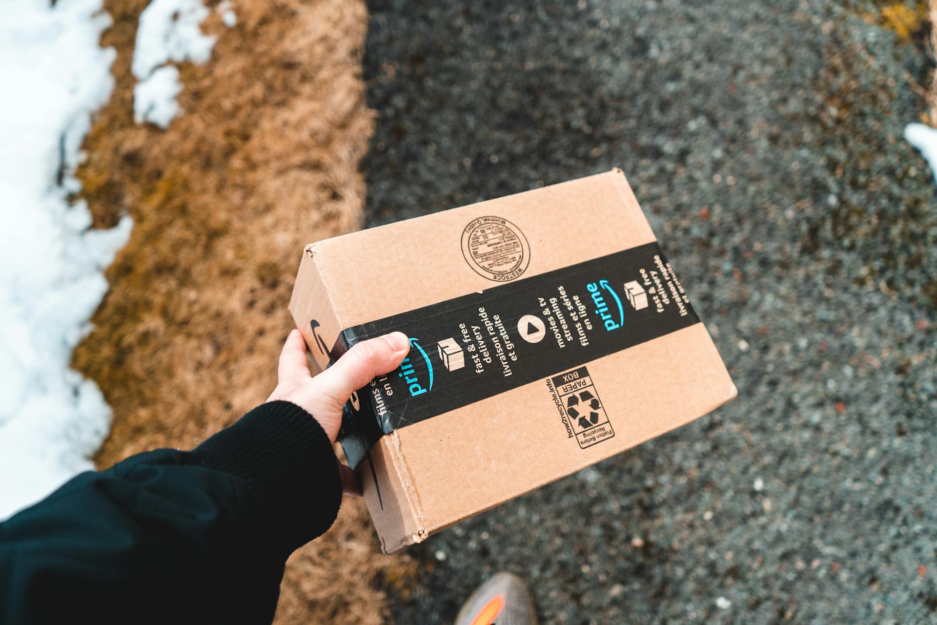 Una persona sostiene un paquete de Amazon | Fuente: Pexels