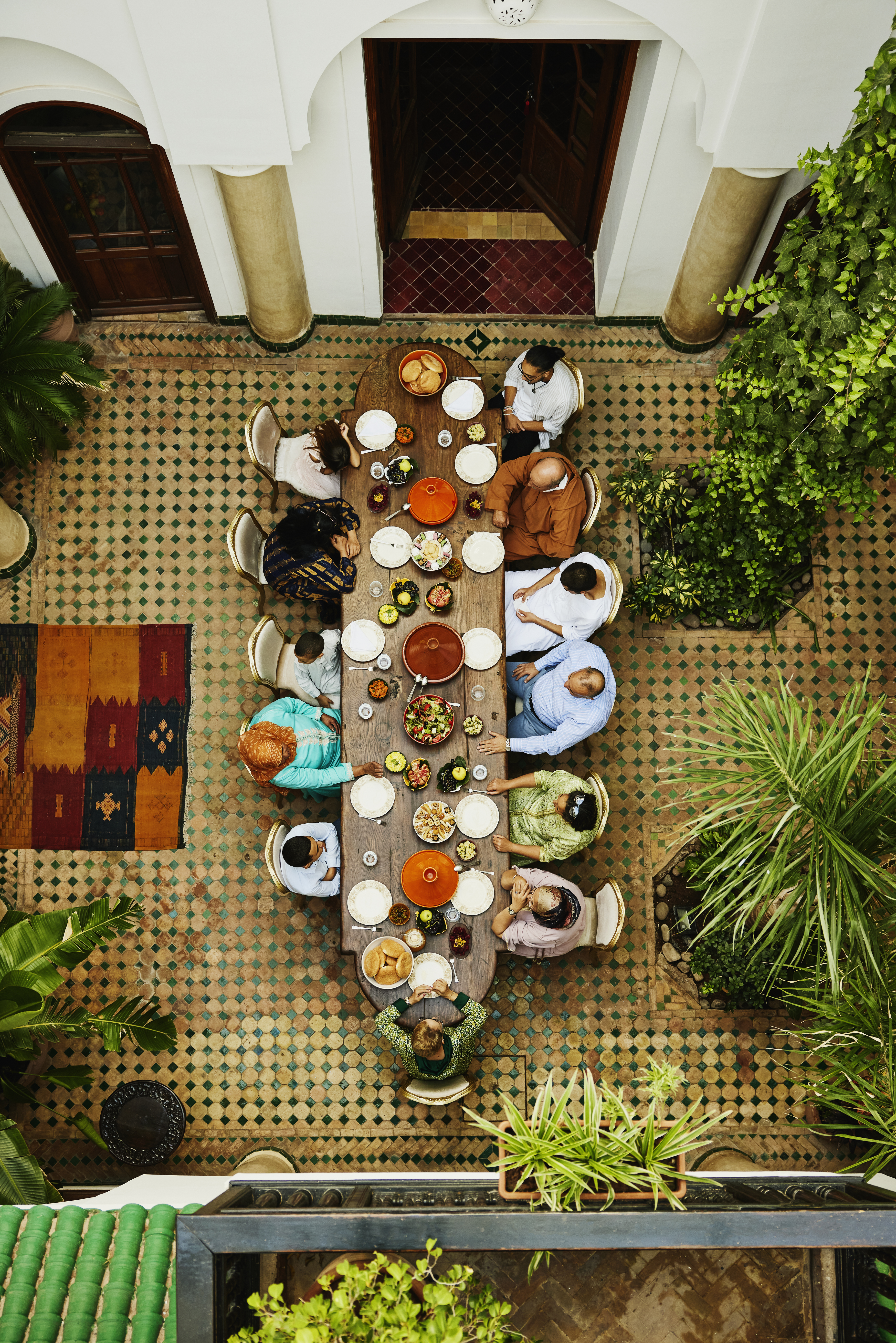 Gran mesa con gente sentada a su alrededor | Fuente: Getty Images