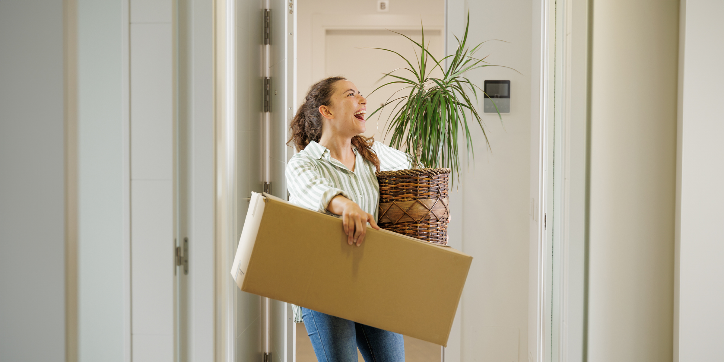 Una mujer con una caja y una planta | Fuente: Shutterstock