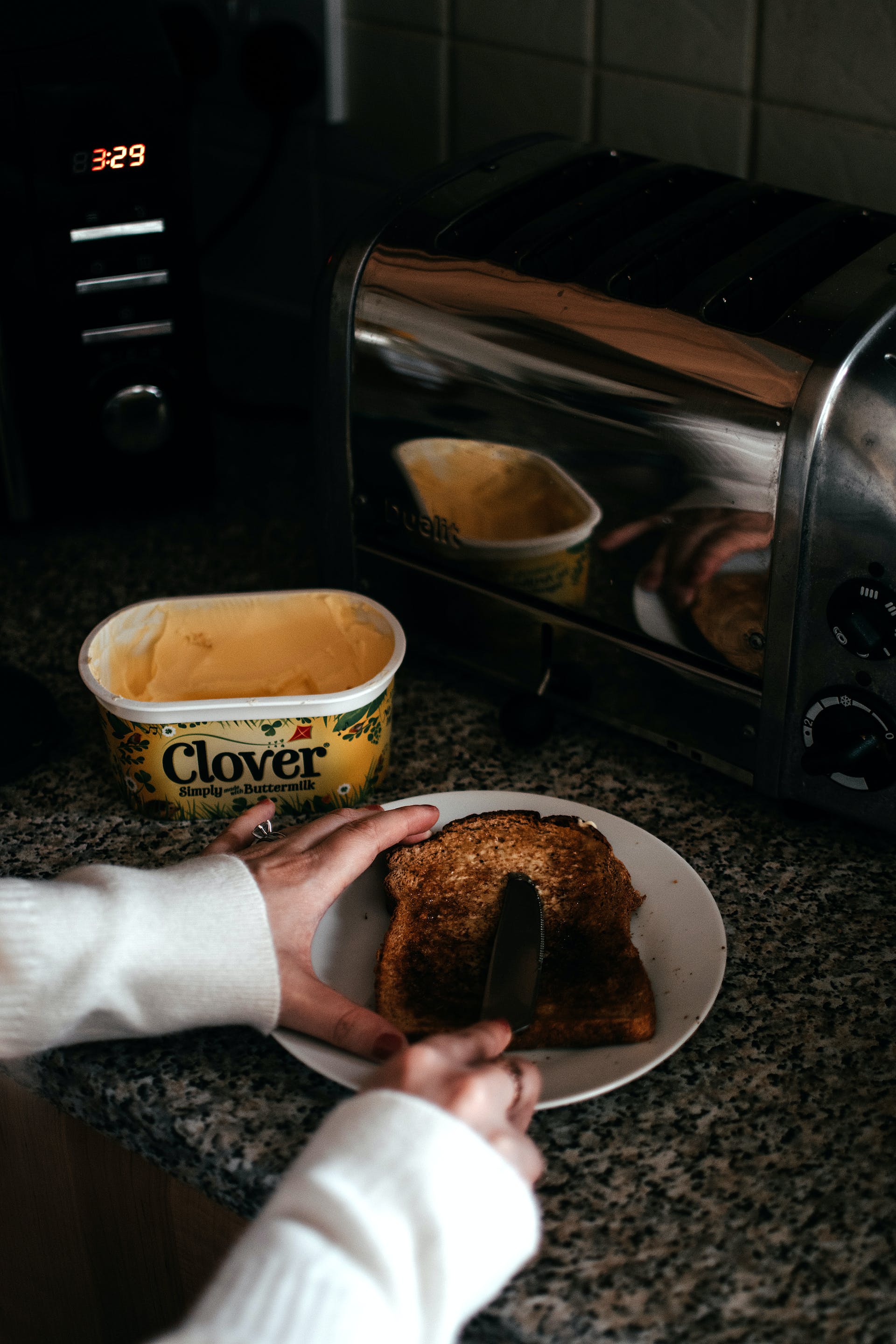 Persona untando mantequilla en una tostada | Foto: Pexels