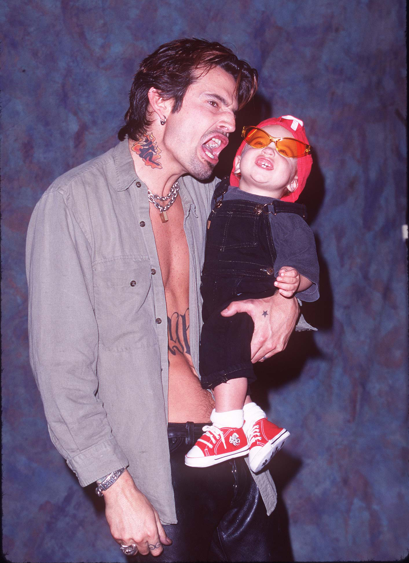 Tommy Lee reacciona mientras sostiene a su hijo Brandon en el Guitar Center de Hollywood, California, el 20 de mayo de 1997 | Fuente: Getty Images