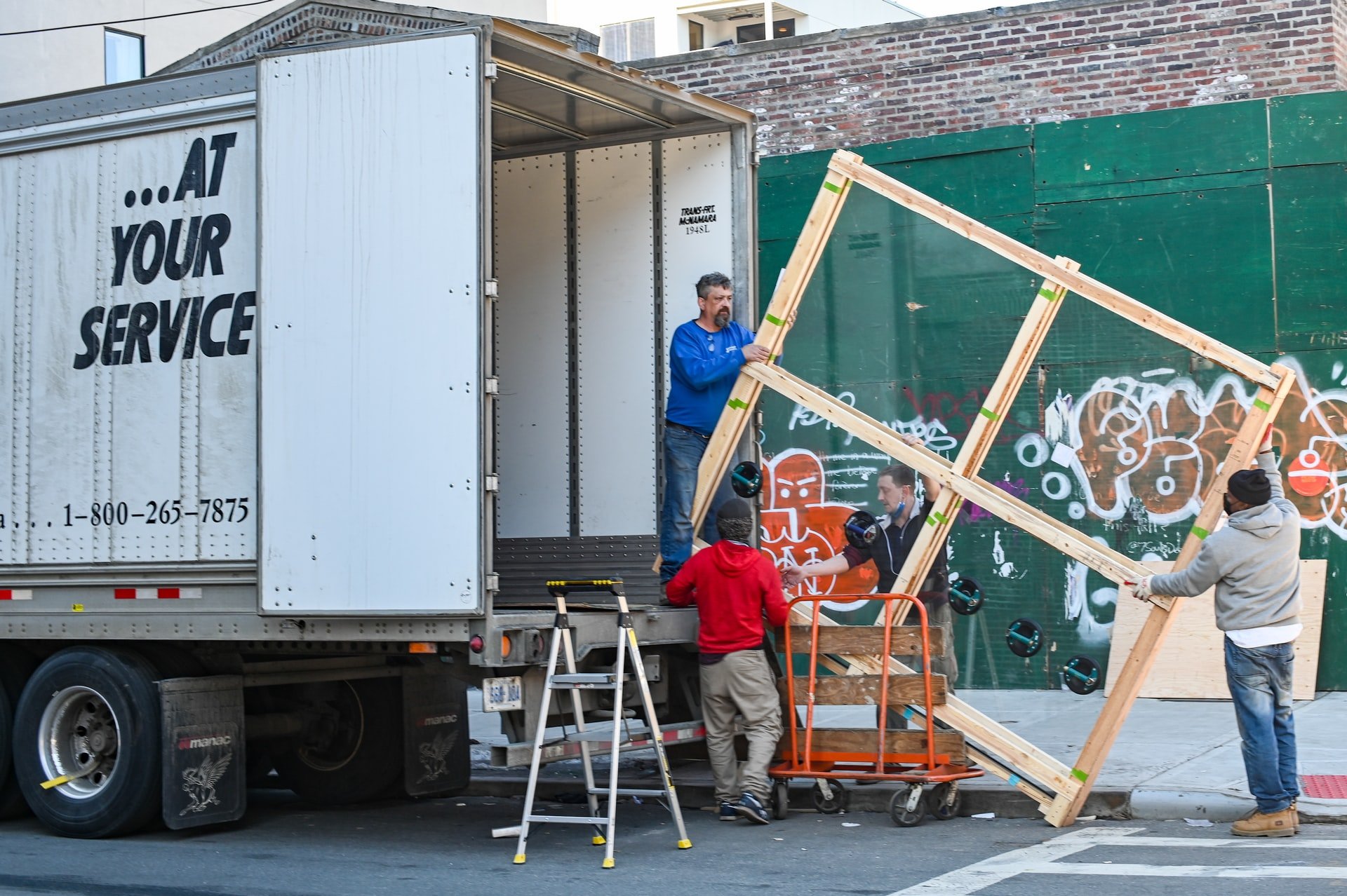 Repartidores cargando un mueble en un camión. | Foto: Unsplash