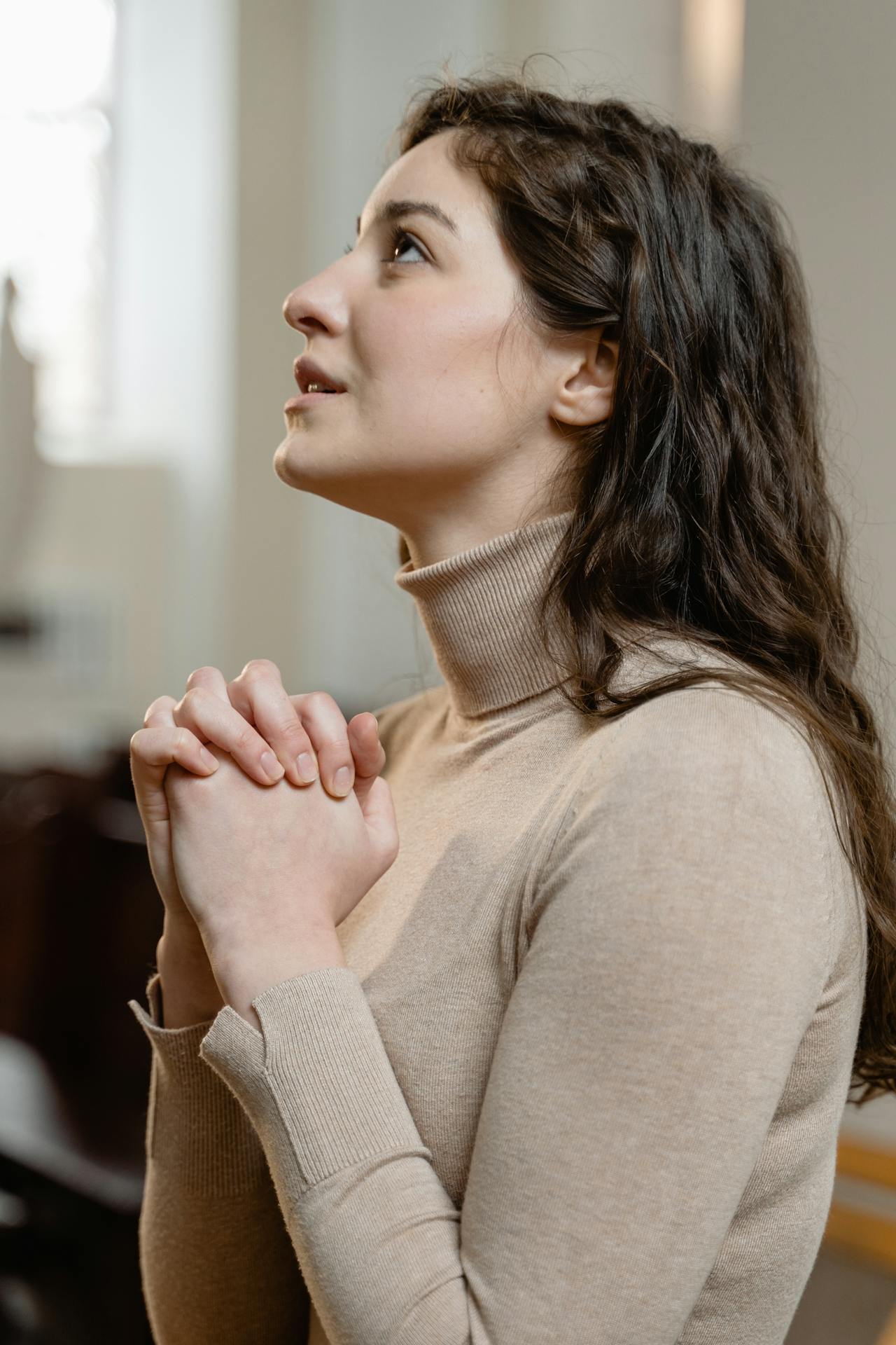 Una joven desesperada en una iglesia | Fuente: Pexels