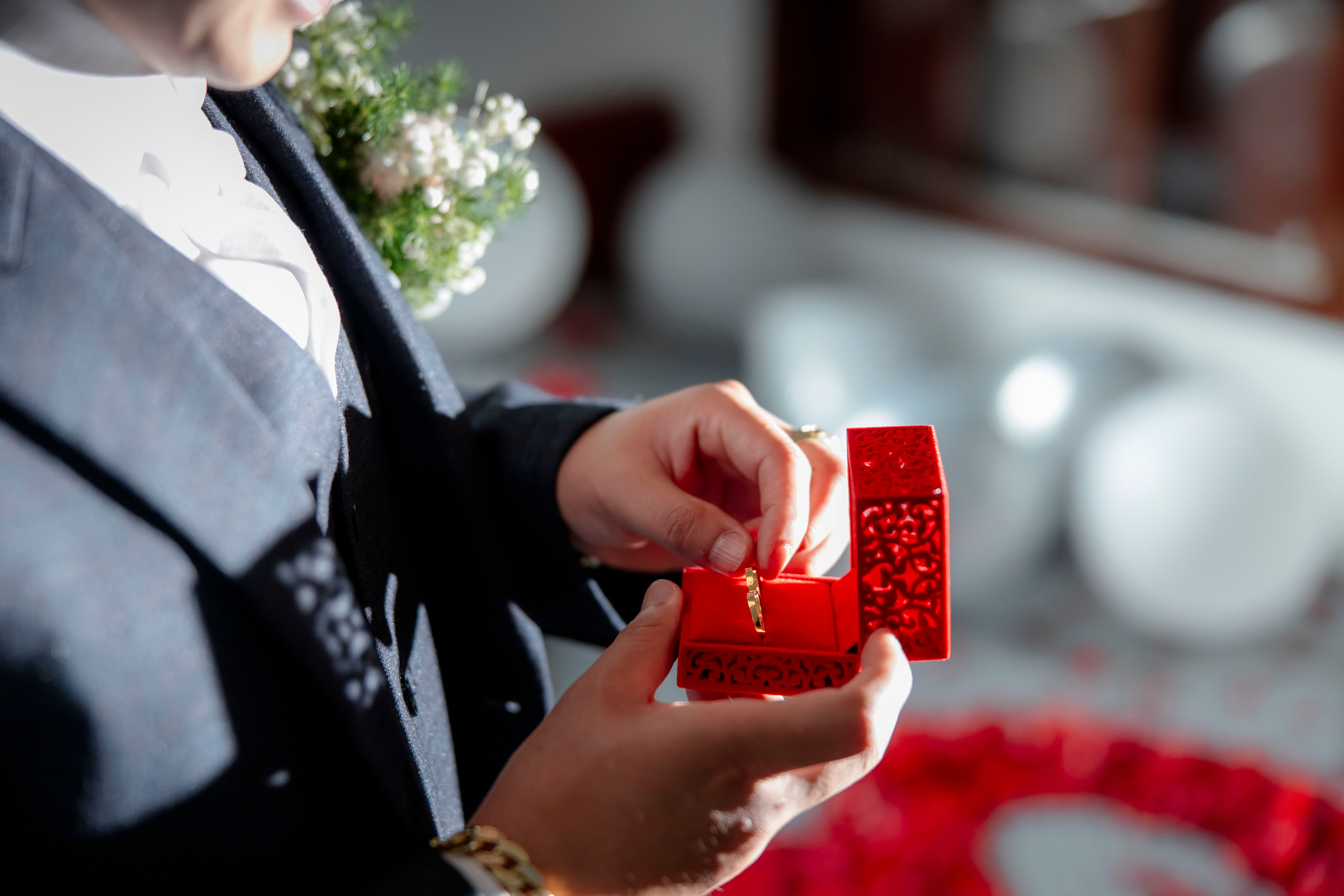 Hombre sosteniendo una caja roja con un anillo de compromiso | Fuente: Pexels