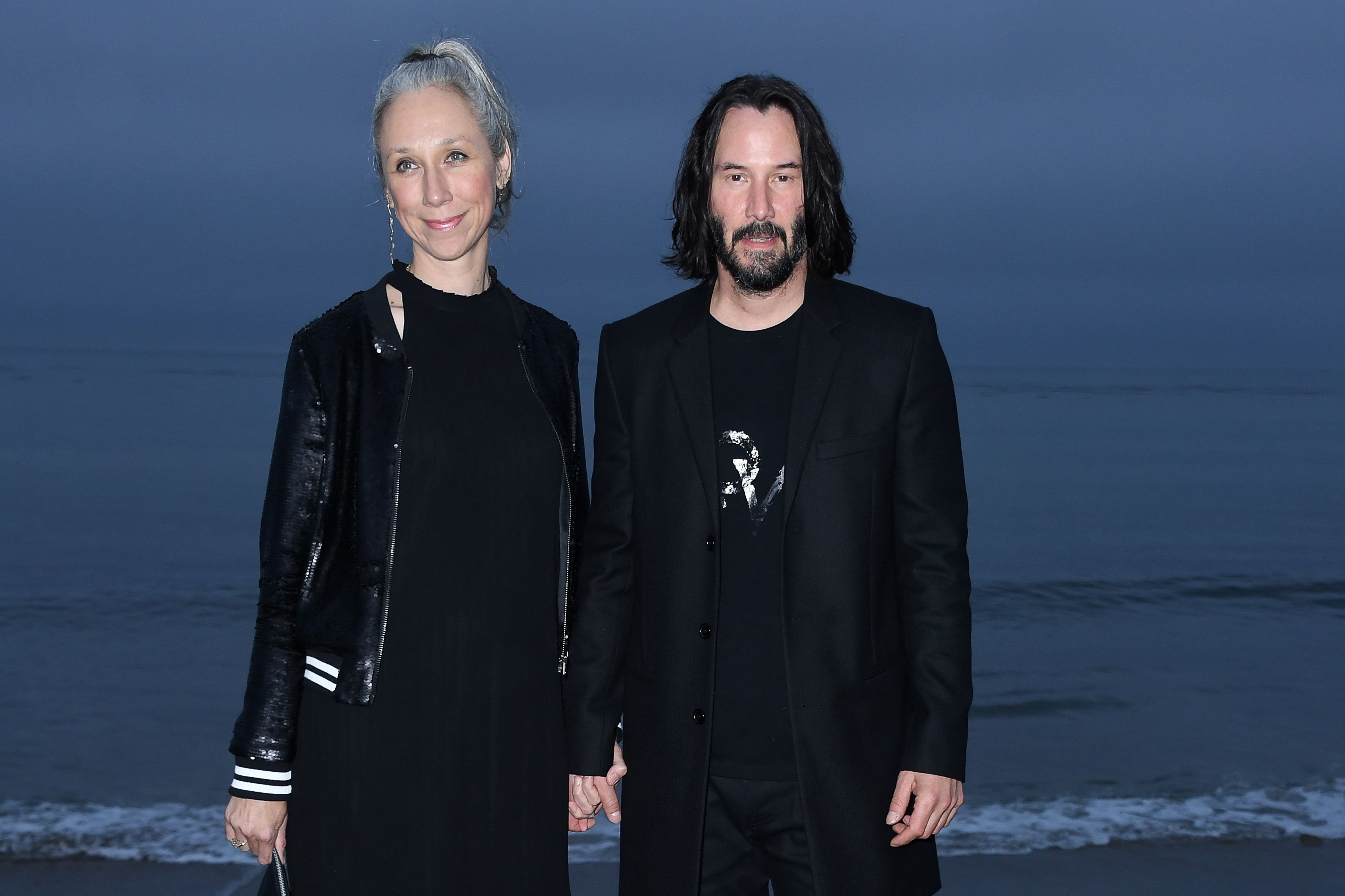 Keanu Reeves y Alexandra Grant llegando al desfile de primavera-verano 2020 de Saint Laurent para hombres el 6 de junio de 2019. | Foto: Getty Images