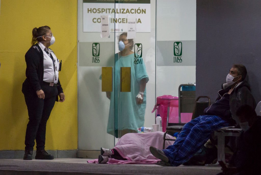 Personas que afirman haber experimentado síntomas de COVID-19 esperan fuera de una sala de emergencias.| Foto: Getty Images