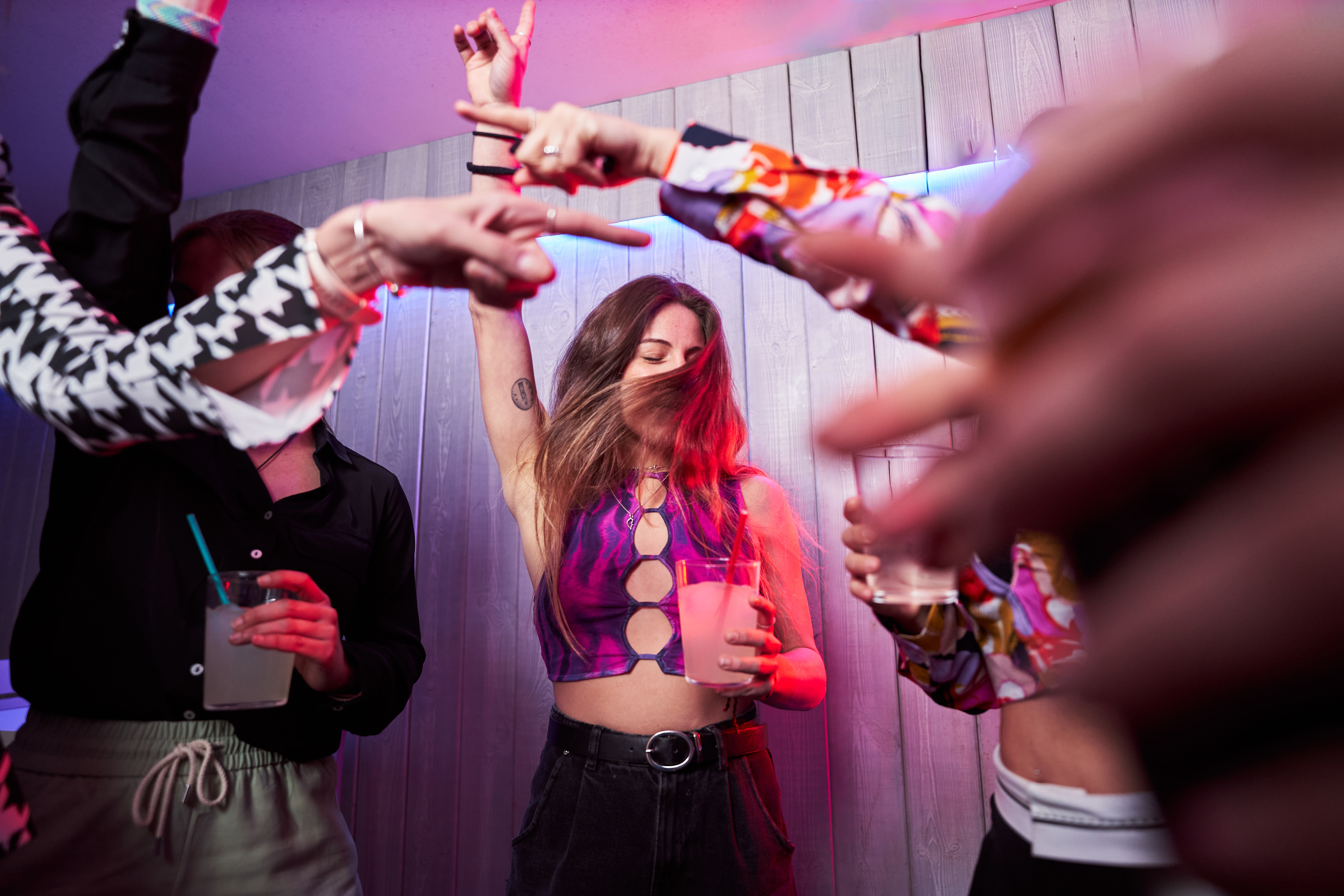 Amigos felices bailando juntos en una discoteca | Fuente: Getty Images