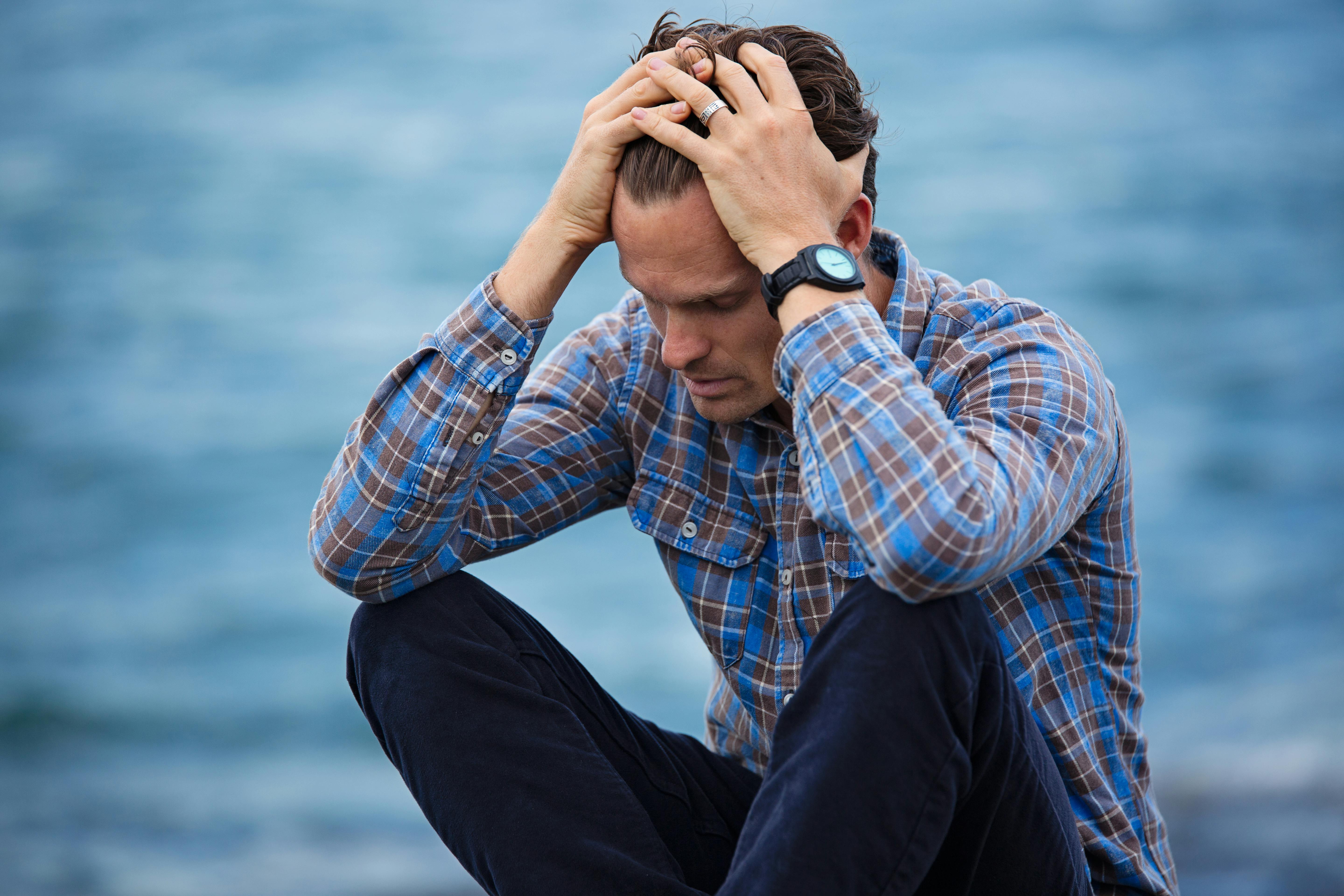 Hombre cansado pensando junto al mar | Fuente: Pexels