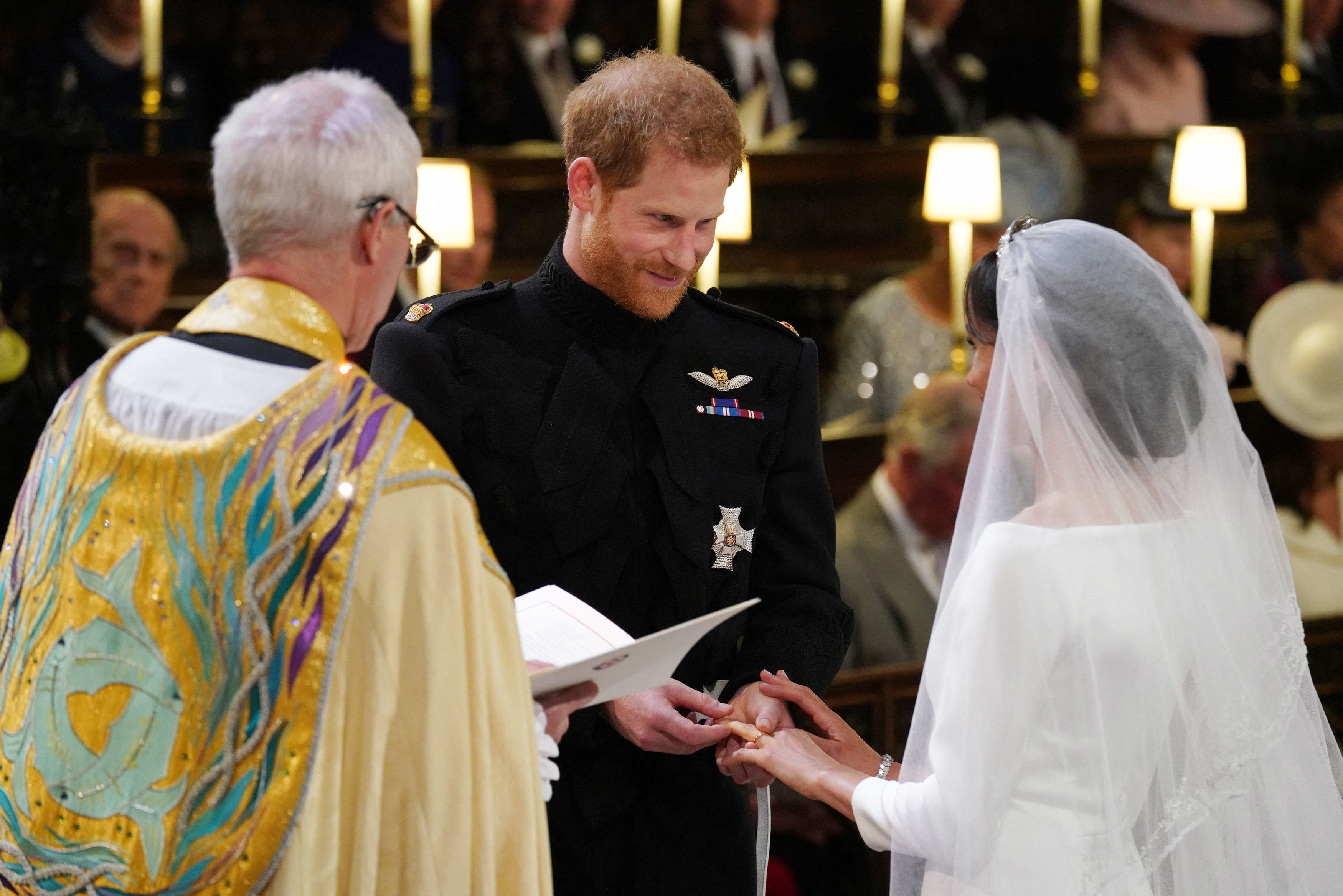 El príncipe Harry, duque de Sussex, coloca el anillo de boda en el dedo de Meghan Markle durante su ceremonia nupcial en la capilla de San George, en el castillo de Windsor, el 19 de mayo de 2018 | Fuente: Getty Images