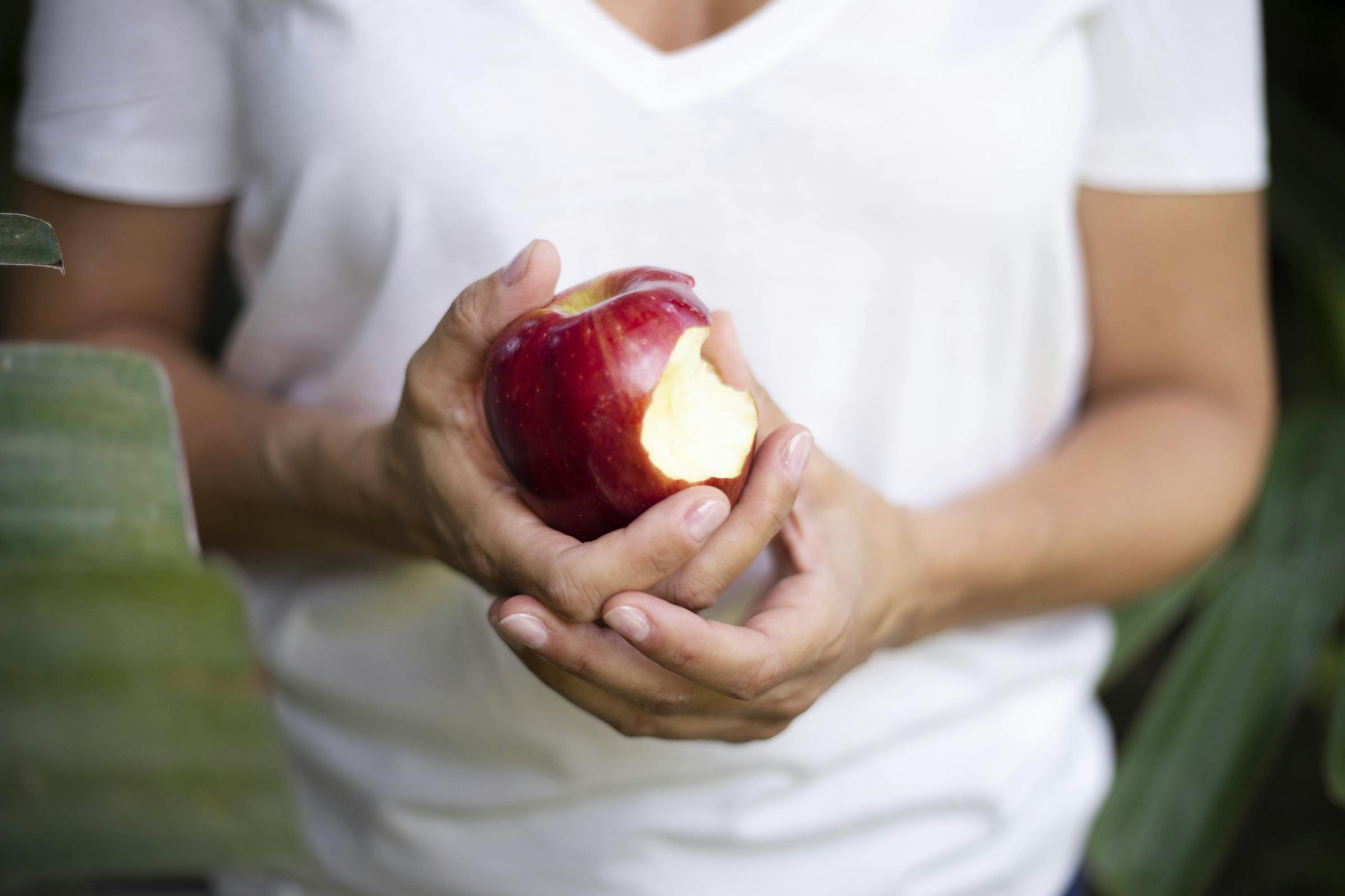 Una mujer sujetando una manzana mordida | Fuente: Pexels