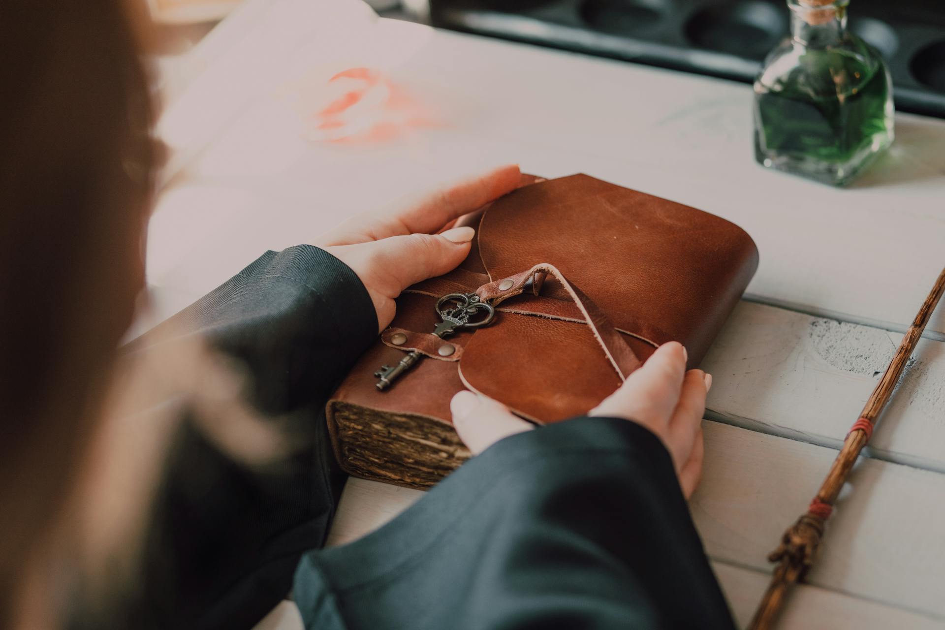 Una mujer con un diario de cuero marrón en la mano | Fuente: Pexels