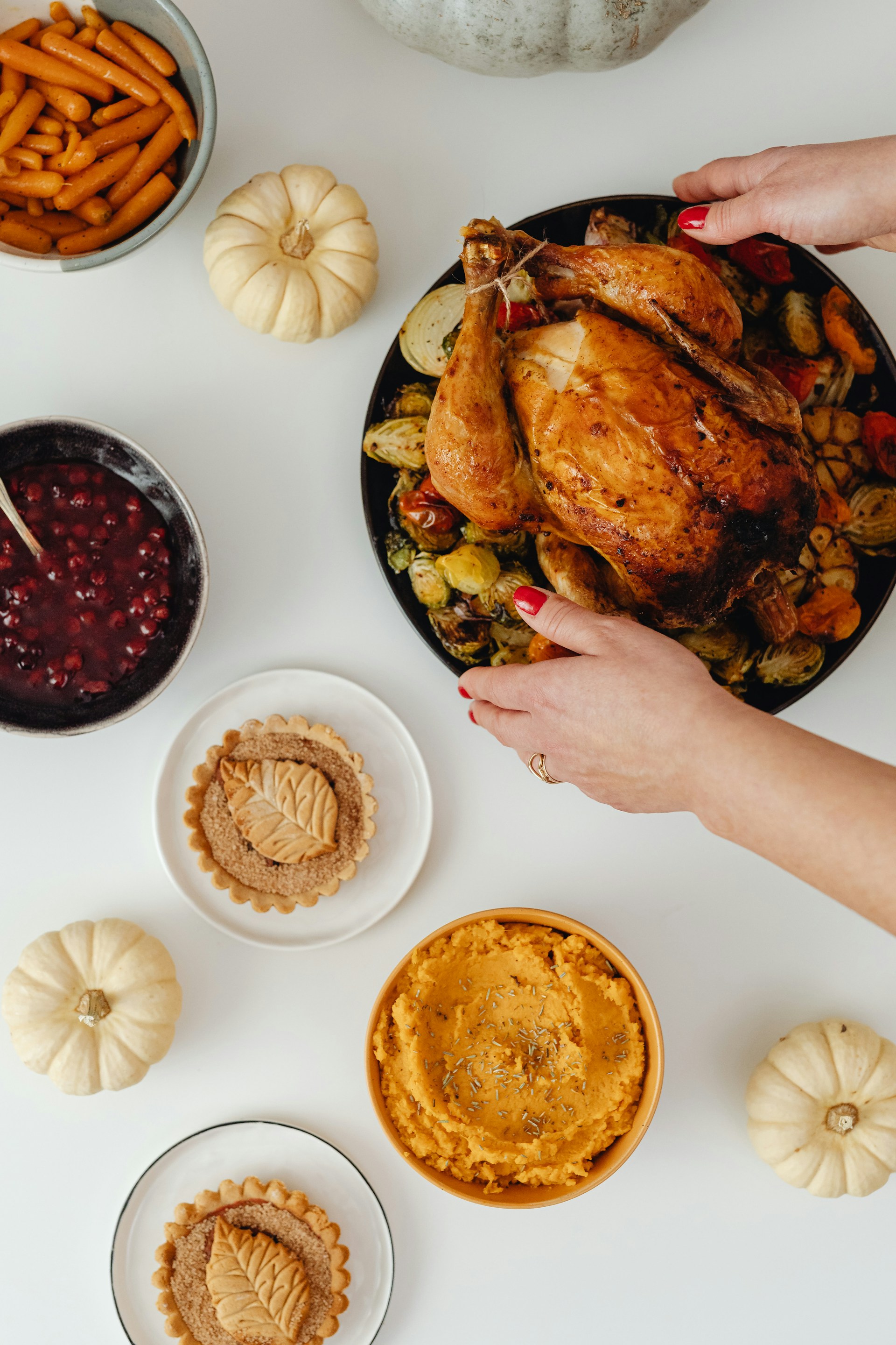 Una mujer colocando un plato de pollo asado sobre la mesa | Fuente: Unsplash