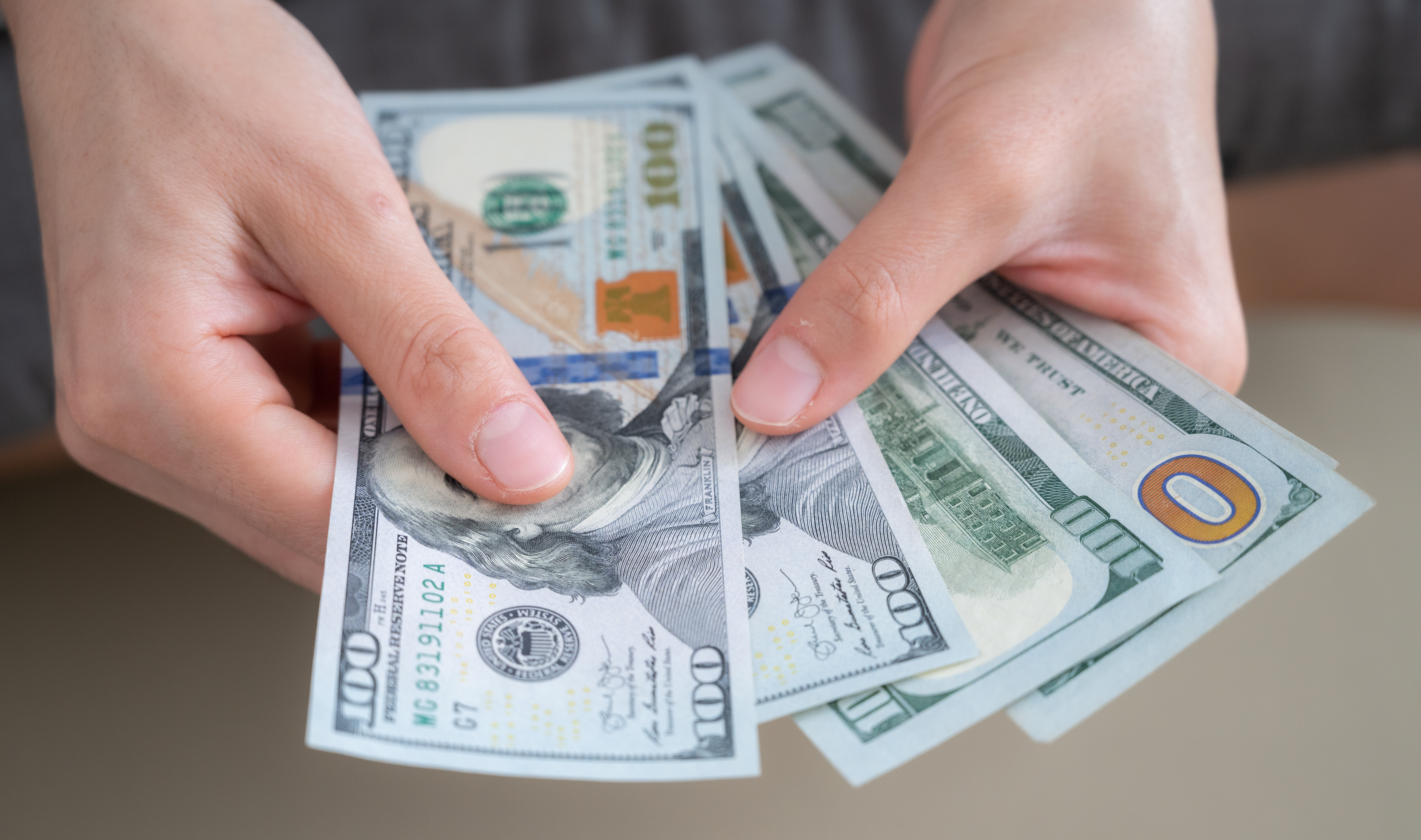 Manos contando dólares americanos | Foto: Getty Images