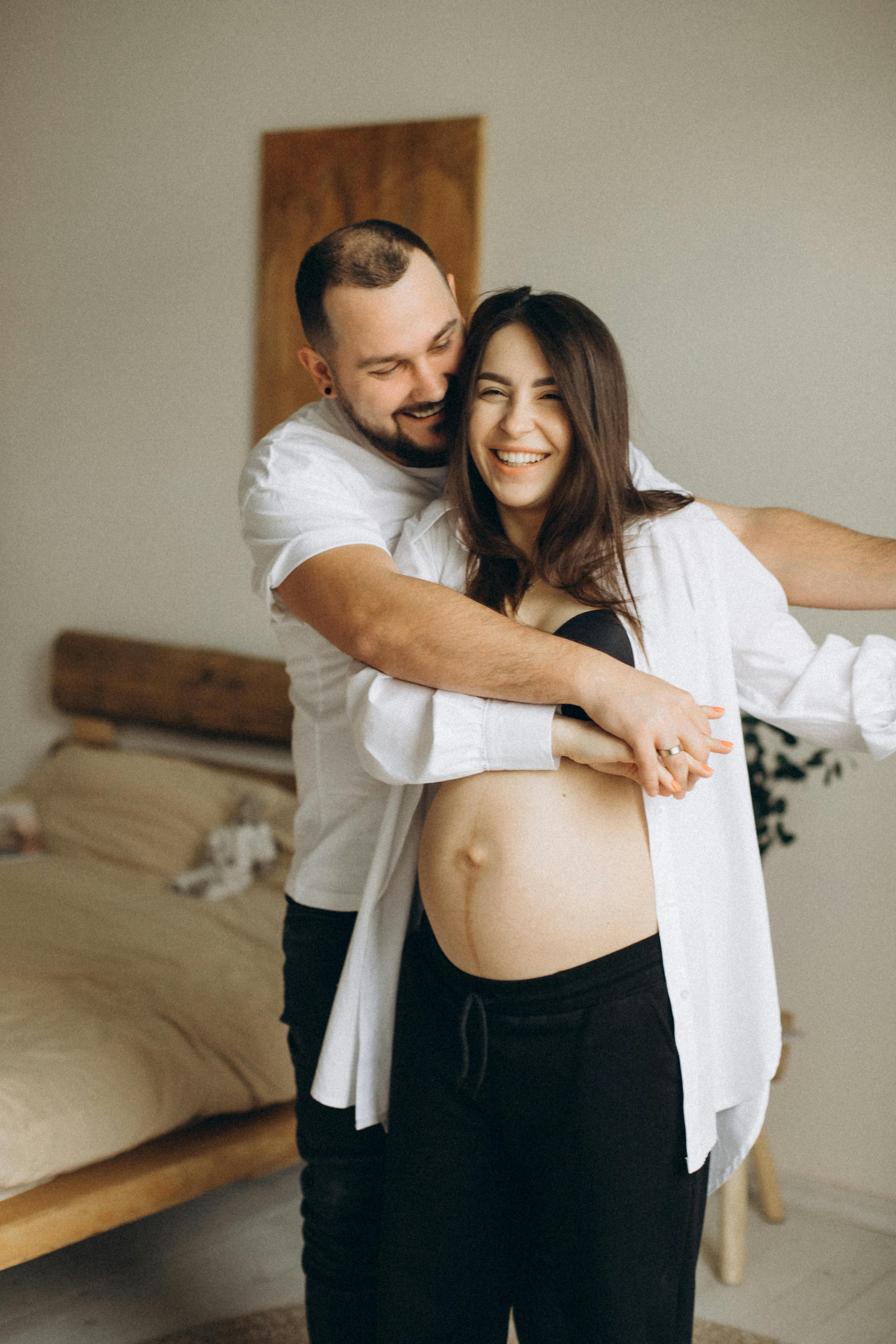 Un hombre abraza a su mujer embarazada | Foto: Pexels