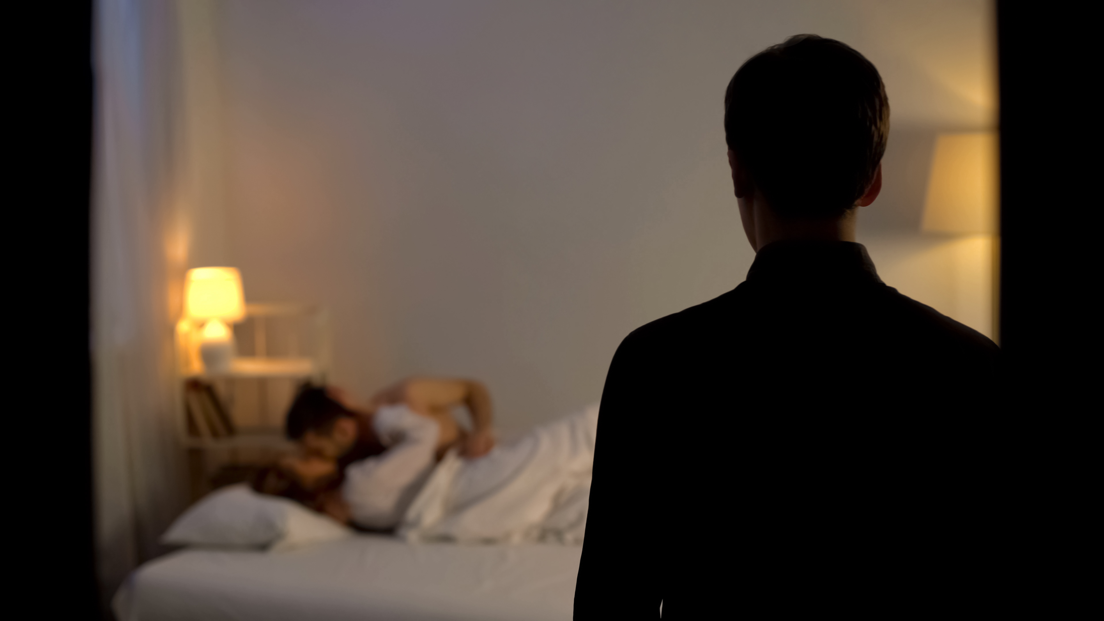 Un marido se queda en estado de shock tras pillar a su mujer engañándole con un amante en la cama. | Foto: Shutterstock