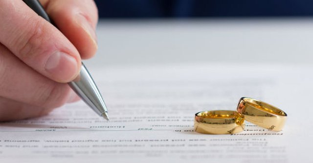 Hombre firma junto anillos de matrimonio | Foto: Shutterstock