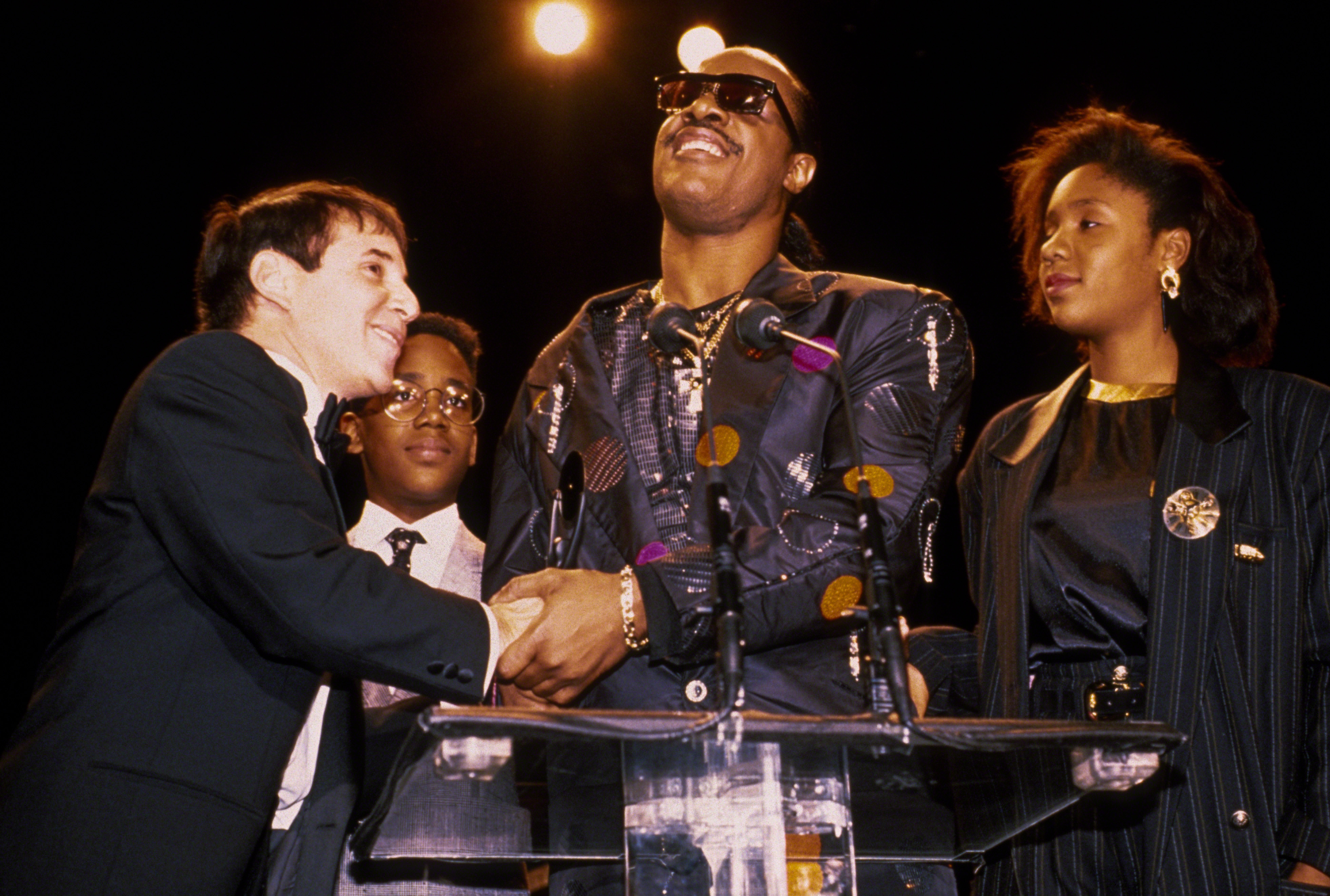 Paul Simon, Keita y Stevie Wonder, y Aisha Morris en la Ceremonia de Inducción al Salón de la Fama del Rock N Roll de 1989, el 1 de enero de 1989, en Nueva York | Fuente: Getty Images