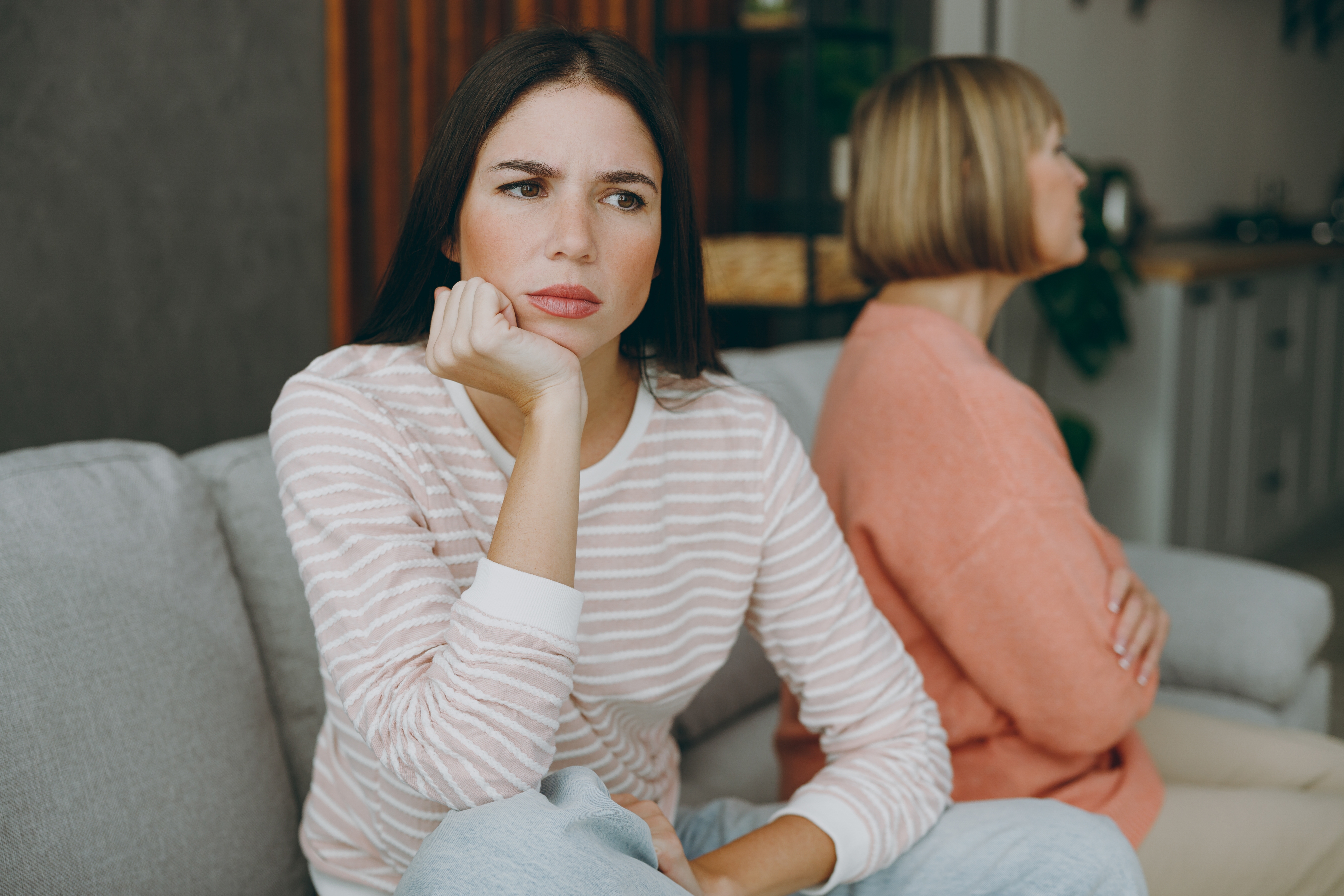 Una mujer mayor y su hija sentadas separadas tras un desacuerdo | Fuente: Shutterstock