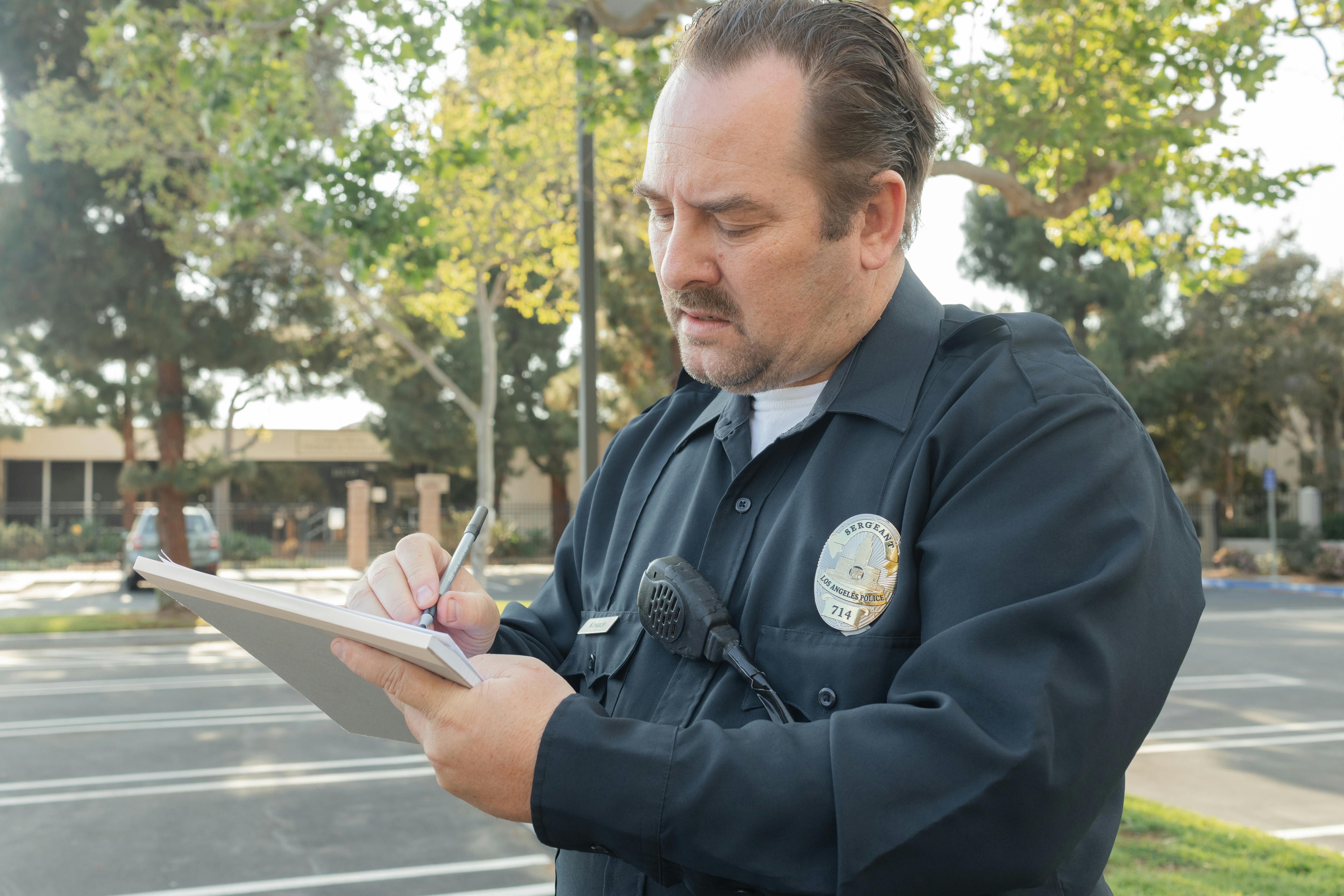 Un policía anotando algo en su bloc de notas | Fuente: Pexels