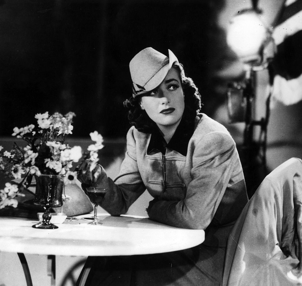 La actriz de cine estadounidense Joan Crawford sentada en una mesa. |Fuente: Getty Images