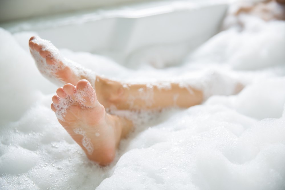 Pies rodeados de espuma en una bañera. | Foto: Shutterstock