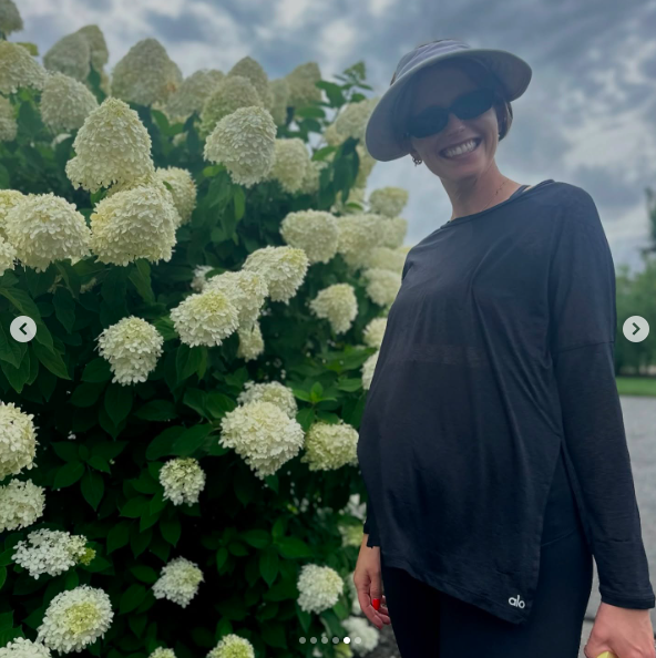 Katherine Schwarzenegger sonriendo junto a unas flores | Fuente: Instagram/prattprattpratt