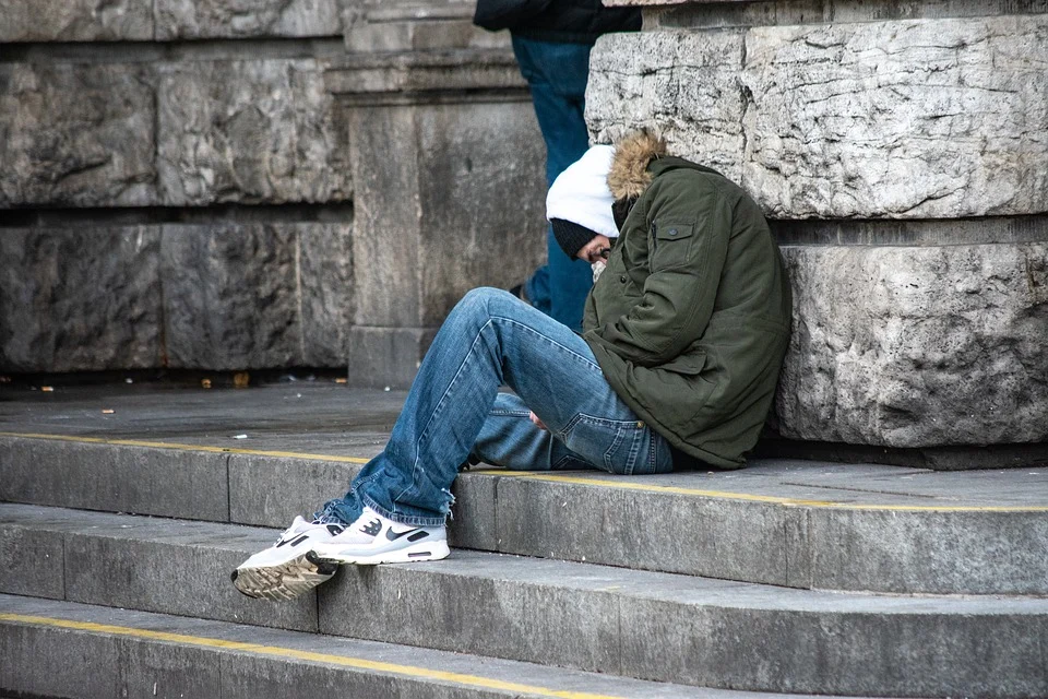Imagen referencial. Persona sin hogar sentada en una acera recostada de una columna. | Foto: Pixabay